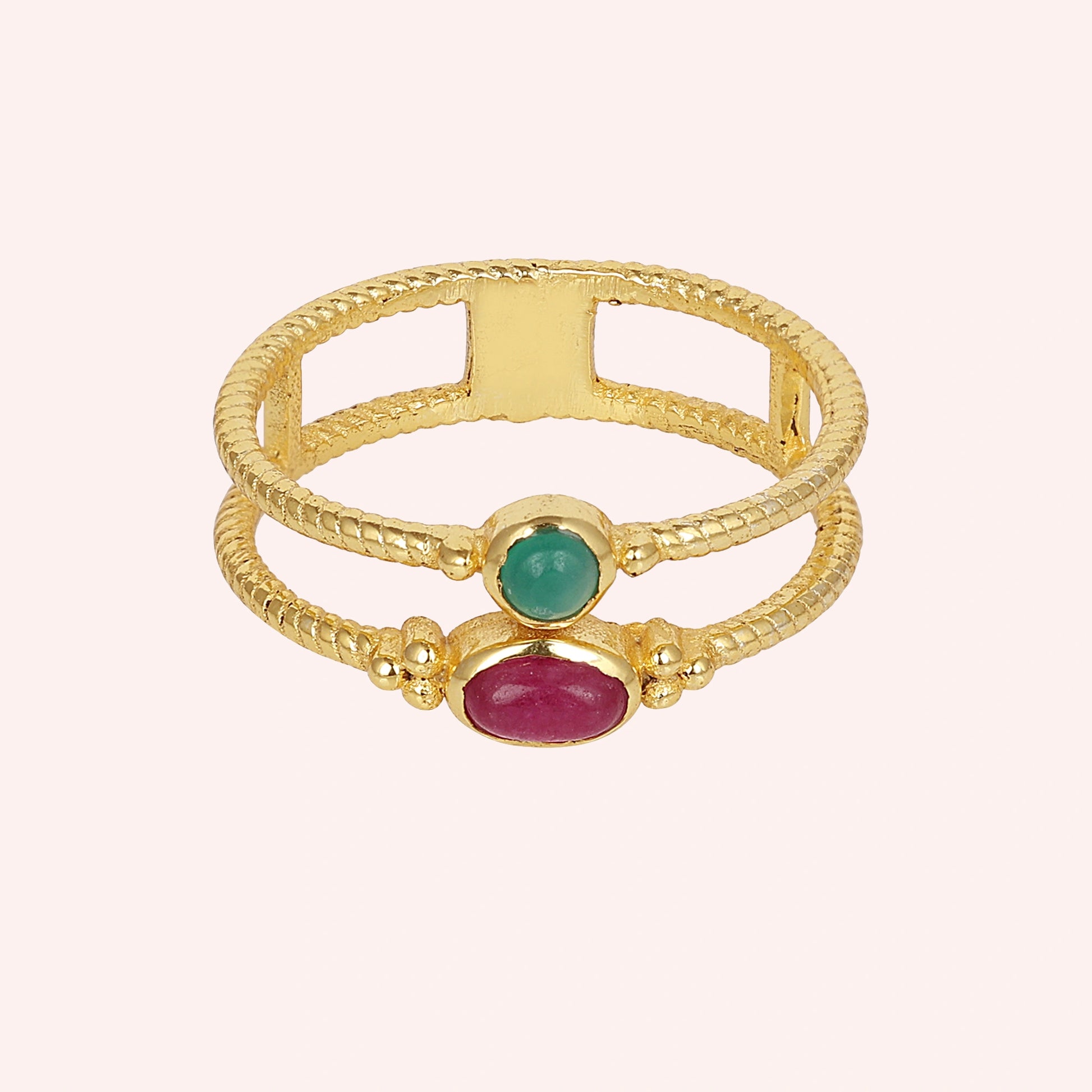 Double_stone_ring_in_gold_plated_silver_in_front_angle_with_ruby_and_green_onyx_stones_on_solid_pink_background