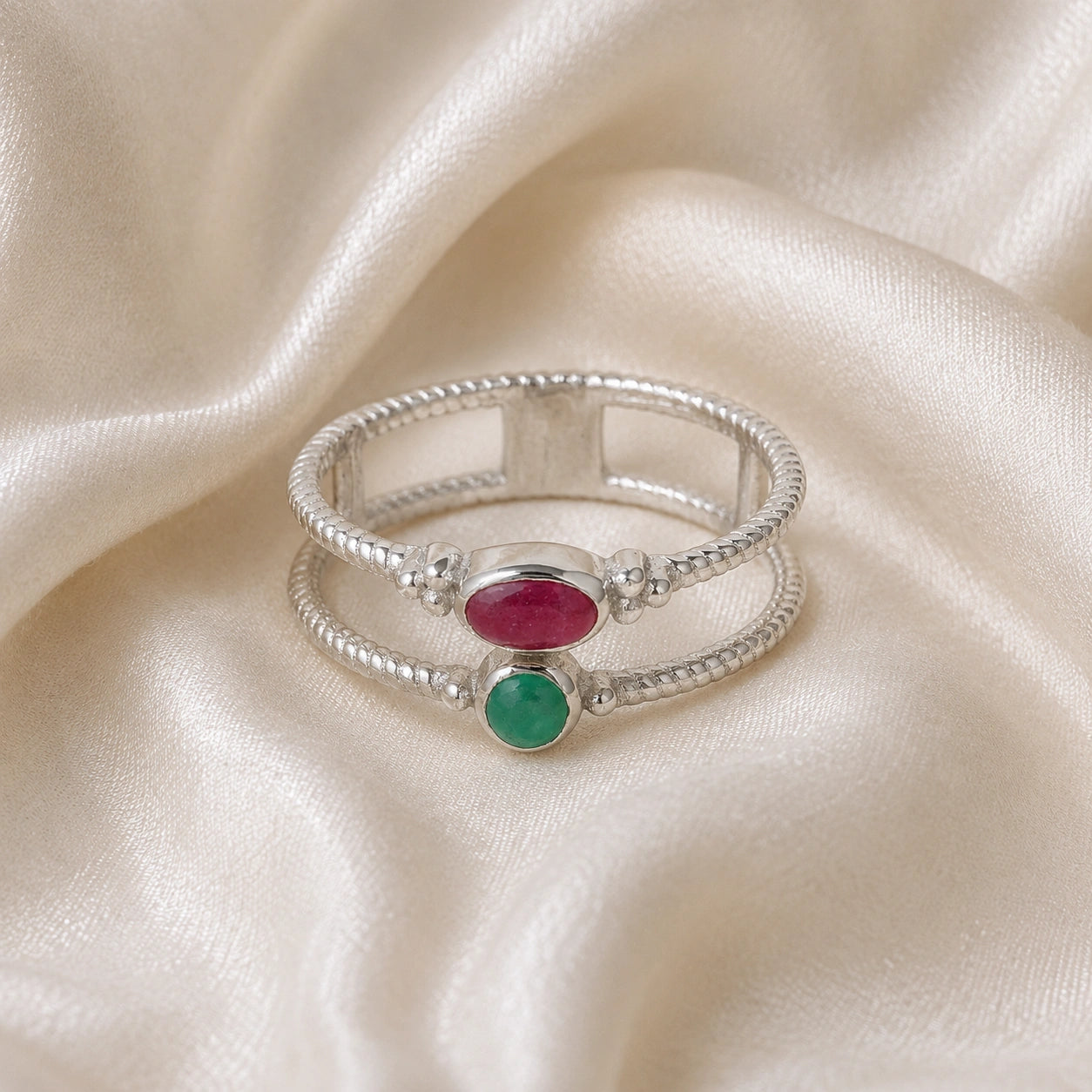 Double_stone_ring_in_sterling_silver_in_front_angle_with_ruby_and_green_onyx_stones_on_soft_fabric_background