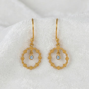Drop_earrings_gold_plated_silver_with_textured_design_and_labradorite_stone_in_front_angle_on_soft_white_fabric_background