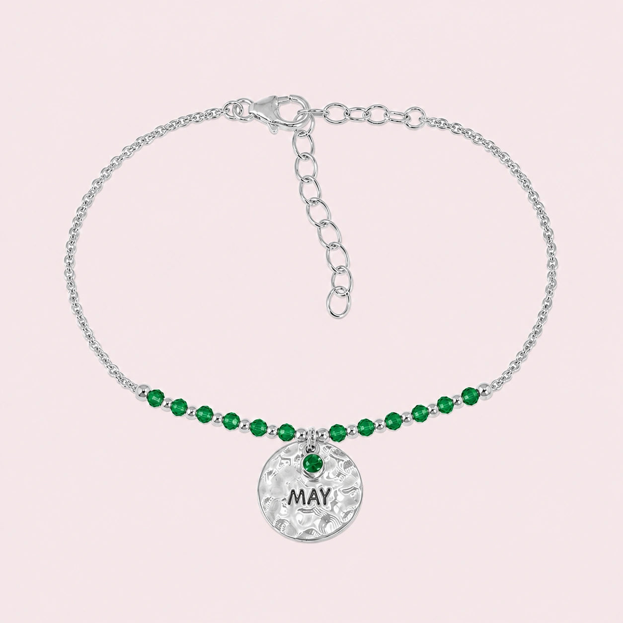 Birthstone_bracelet_in_sterling_silver_with_May_charm_and_emerald_beads_on_fine_chain_on_solid_pink_background