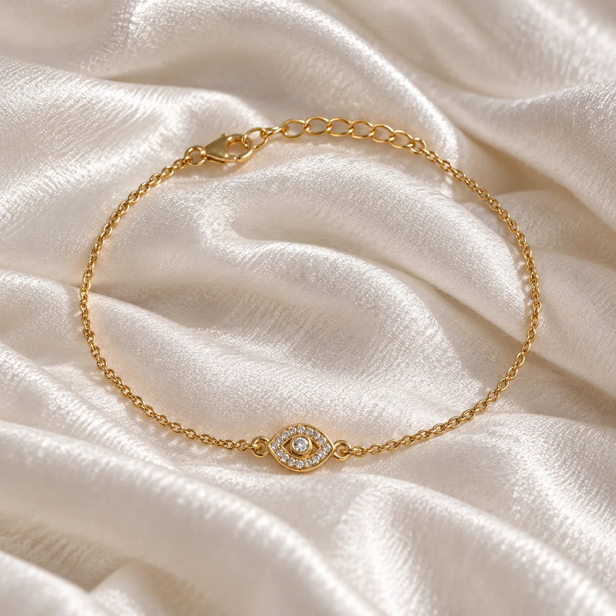 Evil_eye_bracelet_in_gold_plated_silver_with_lab_grown_diamonds_at_front_angle_view_on_soft_fabric_background