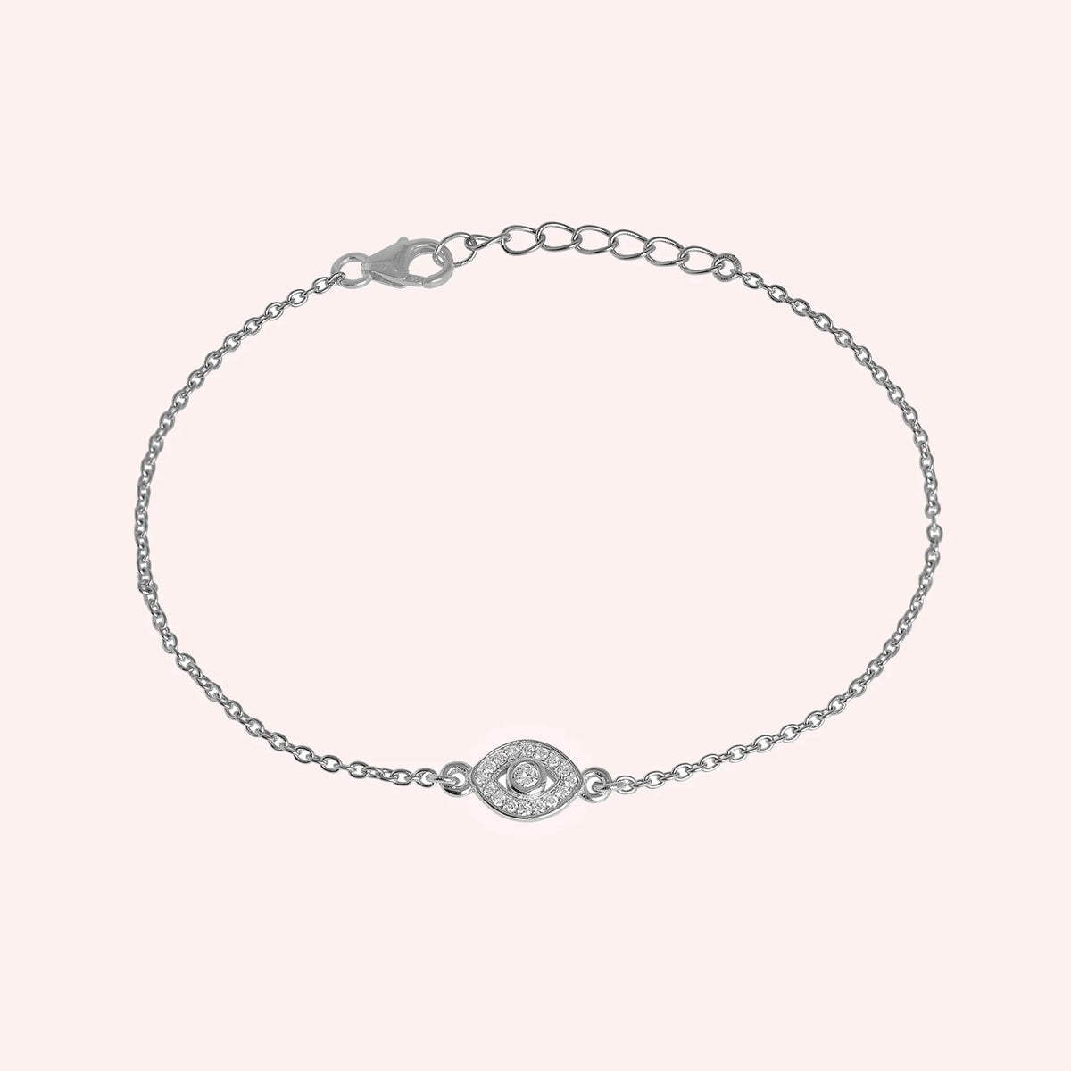 Evil_eye_bracelet_in_sterling_silver_with_CZ_stones_at_front_angle_view_on_solid_pink_background