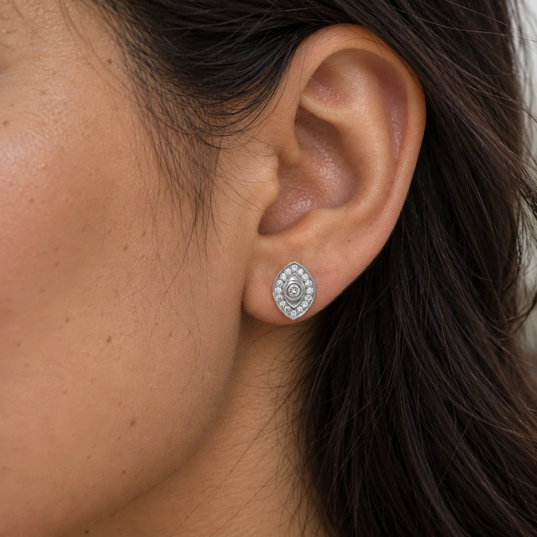 Evil_eye_earrings_in_gold_plated_silver_with_lab_grown_diamonds_at_front_angle_view_on_soft_fabric_background