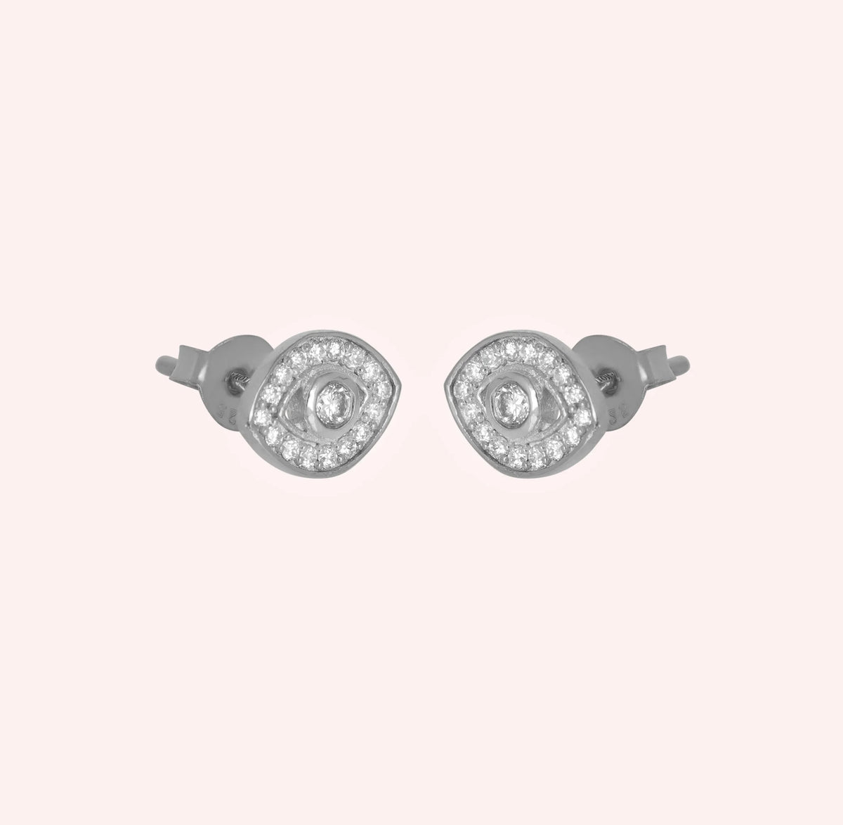 Evil_eye_earrings_in_sterling_silver_with_CZ_stones_at_side_angle_view_on_solid_pink_background