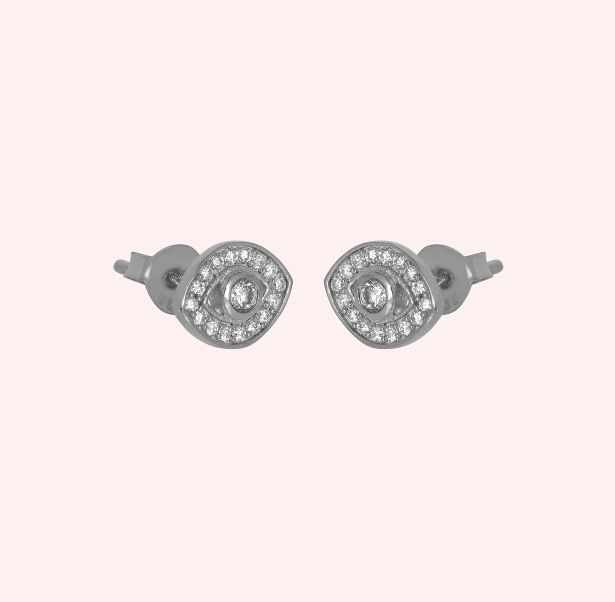 Evil_eye_earrings_in_sterling_silver_with_lab_grown_diamonds_at_slight_angle_view_on_solid_pink_background