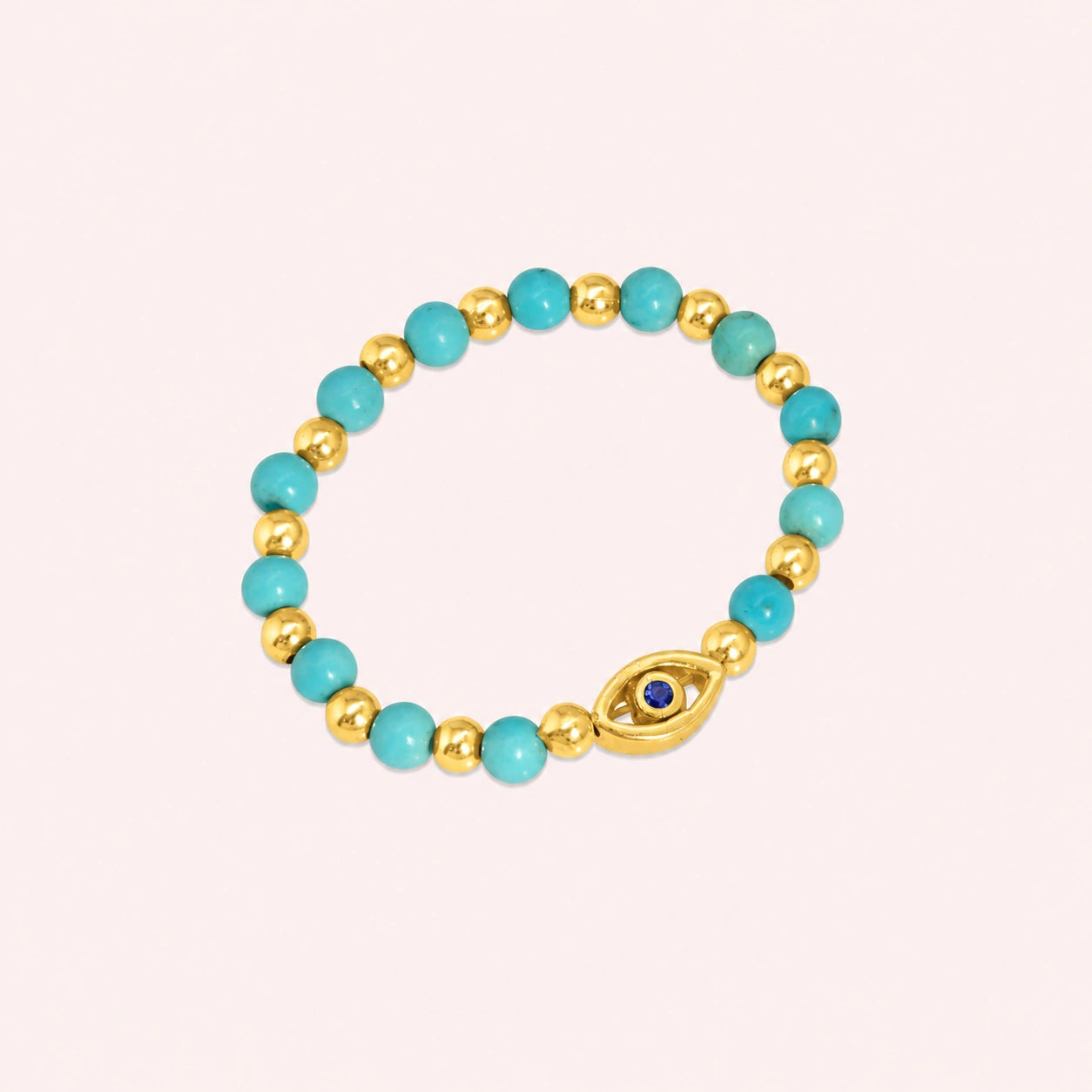 Evil_eye_ring_featuring_turquoise_and_gold_plated_silver_beads_with_blue_iolite_in_slightly_angled_on_solid_pink_background