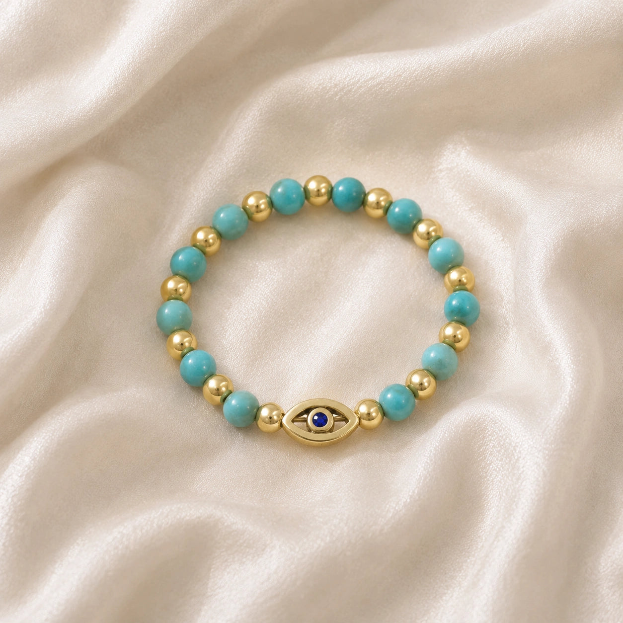 Evil_eye_ring_featuring_turquoise_and_gold_plated_silver_beads_with_blue_iolite_in_front_angle_on_soft_fabric_background
