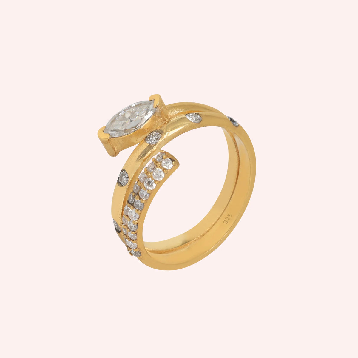 Fashion_ring_in_gold_plated_silver_with_a_spiral_design_and_lab_grown_diamonds_at_side_angle_view_on_solid_pink_background