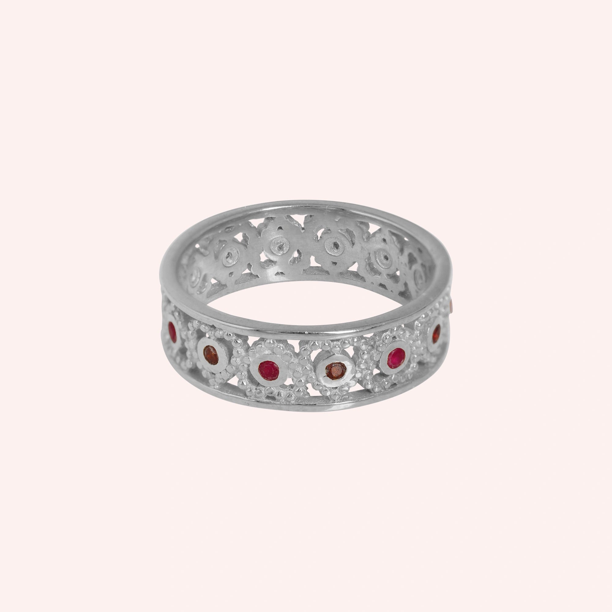 Filigree-ring-with-ruby-and-garnet-stones-sterling-plated-silver-front-view-on-soft-pink-background