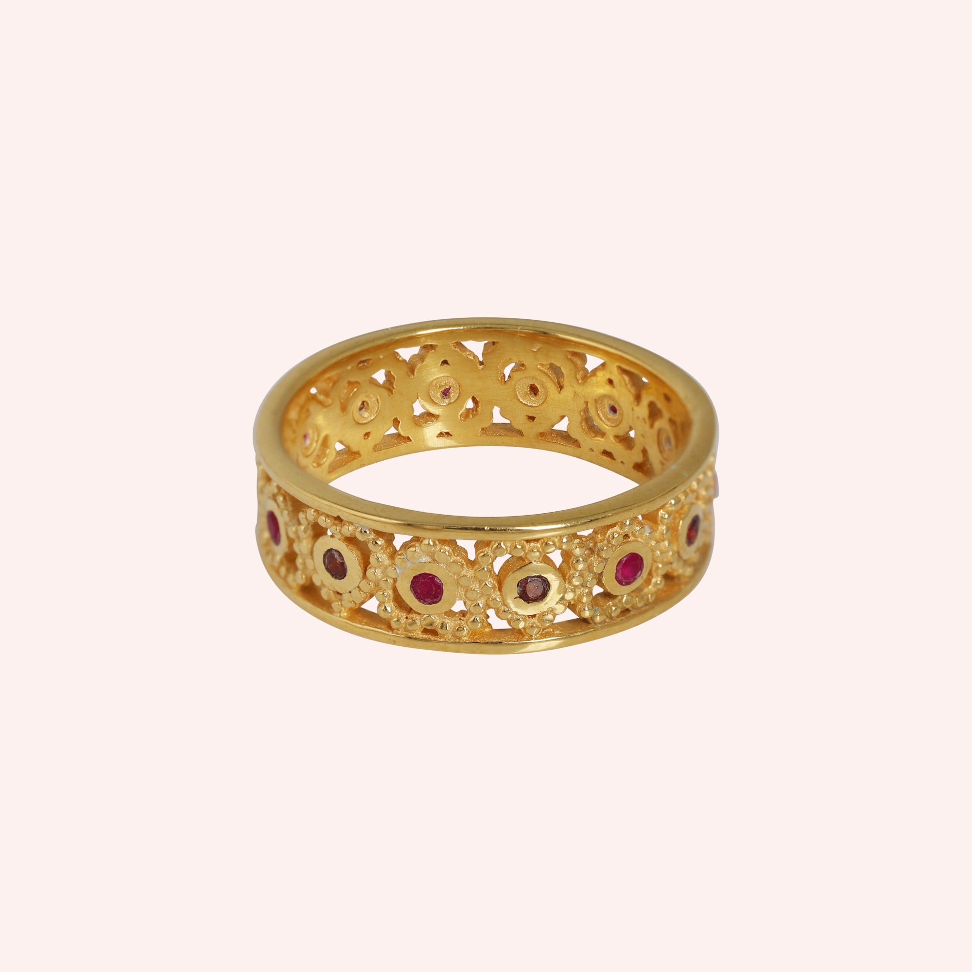 Filigree-ring-with-ruby-and-garnet-stones-gold-plated-silver-front-view-on-soft-pink-background