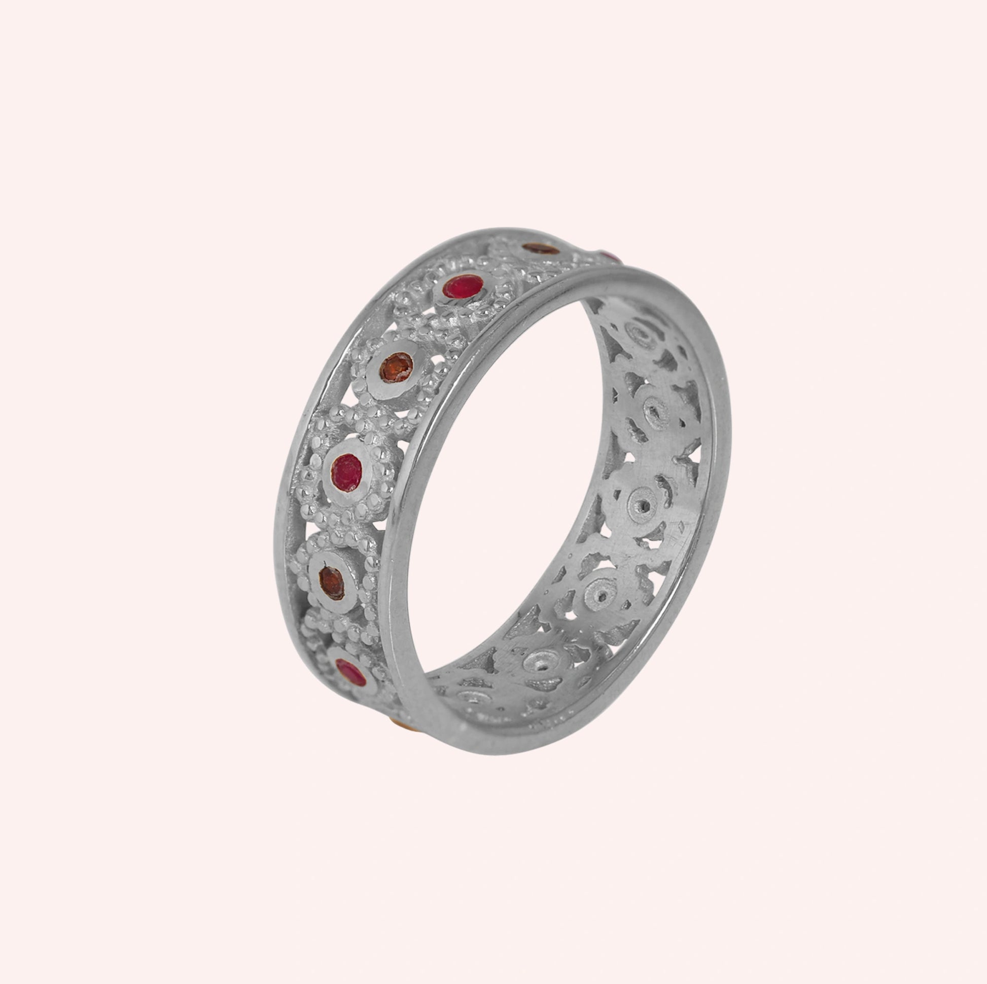Filigree-ring-with-ruby-and-garnet-stones-sterling-silver-angled-view-on-soft-pink-background