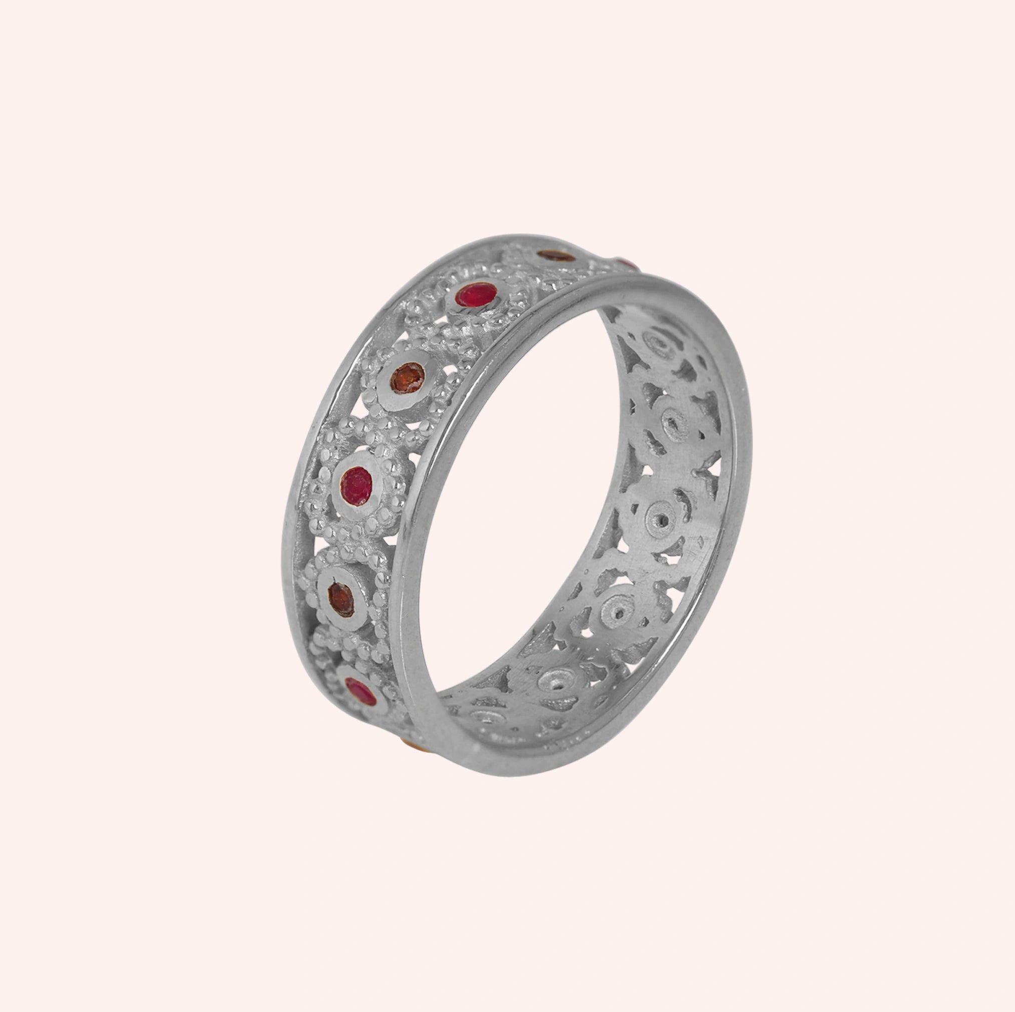 Filigree-ring-with-ruby-and-garnet-stones-sterling-silver-angled-view-on-soft-pink-background