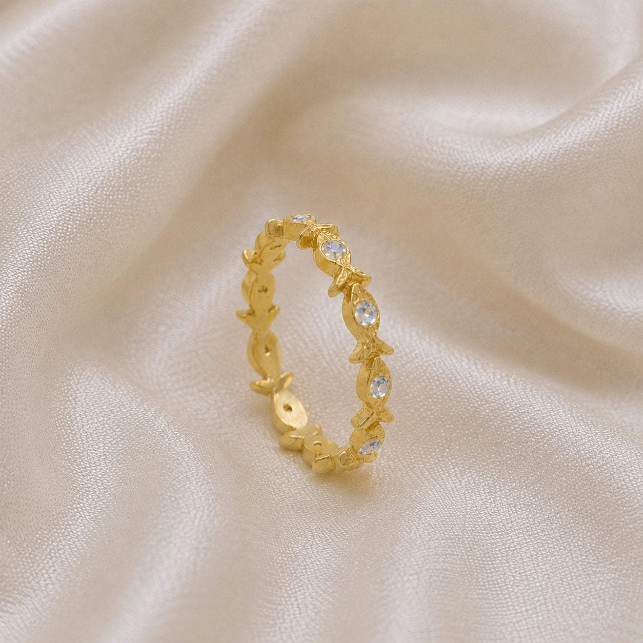 Fish_ring_gold_plated_silver_moonstone_eternity_band_in_side_angle_view_on_soft_fabric_background