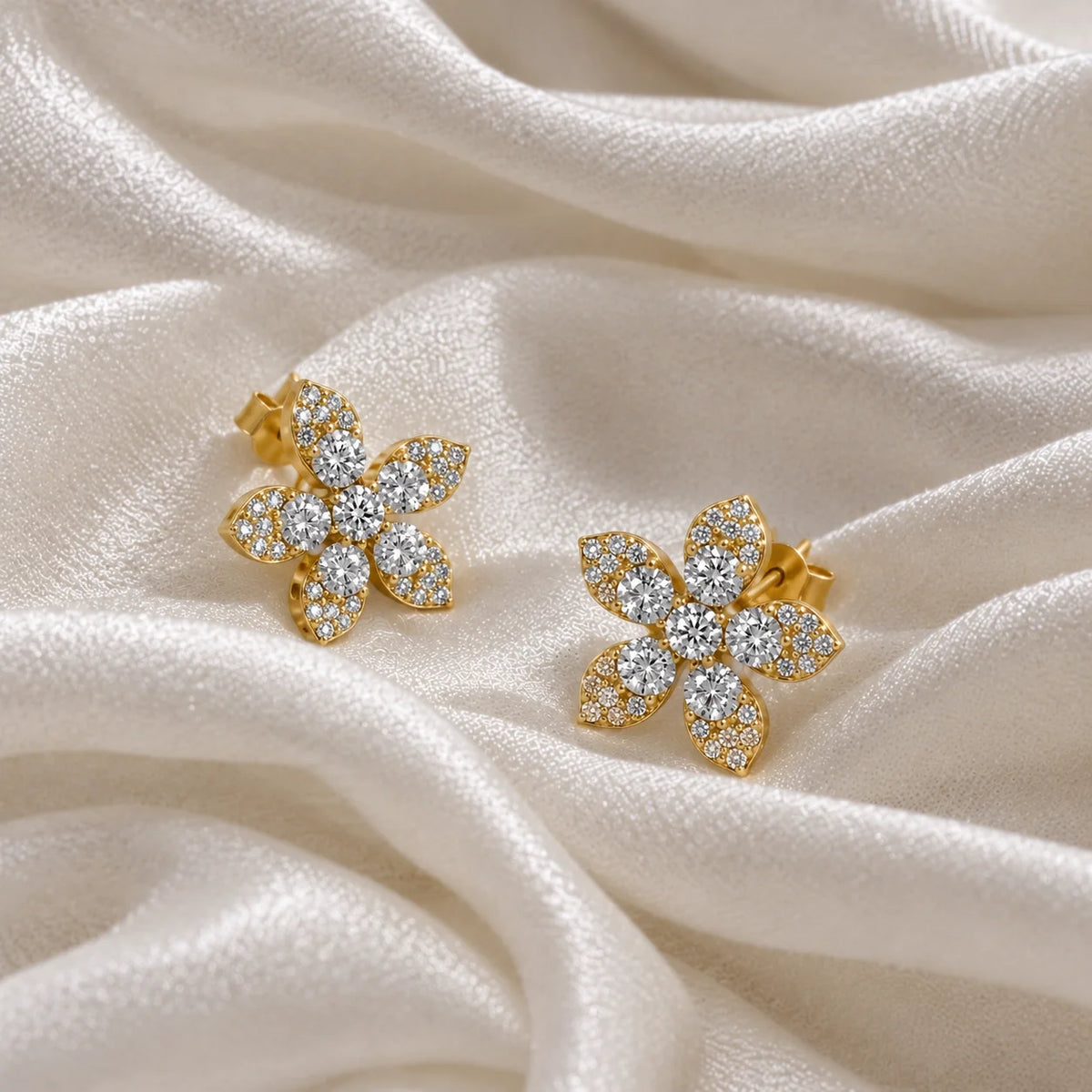 Flower_earrings_in_gold_plated_silver_with_lab_grown_diamonds_at_side_angle_view_on_soft_fabric_background