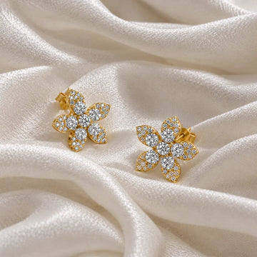 Flower_earrings_in_gold_plated_silver_with_lab_grown_diamonds_at_side_angle_view_on_soft_fabric_background