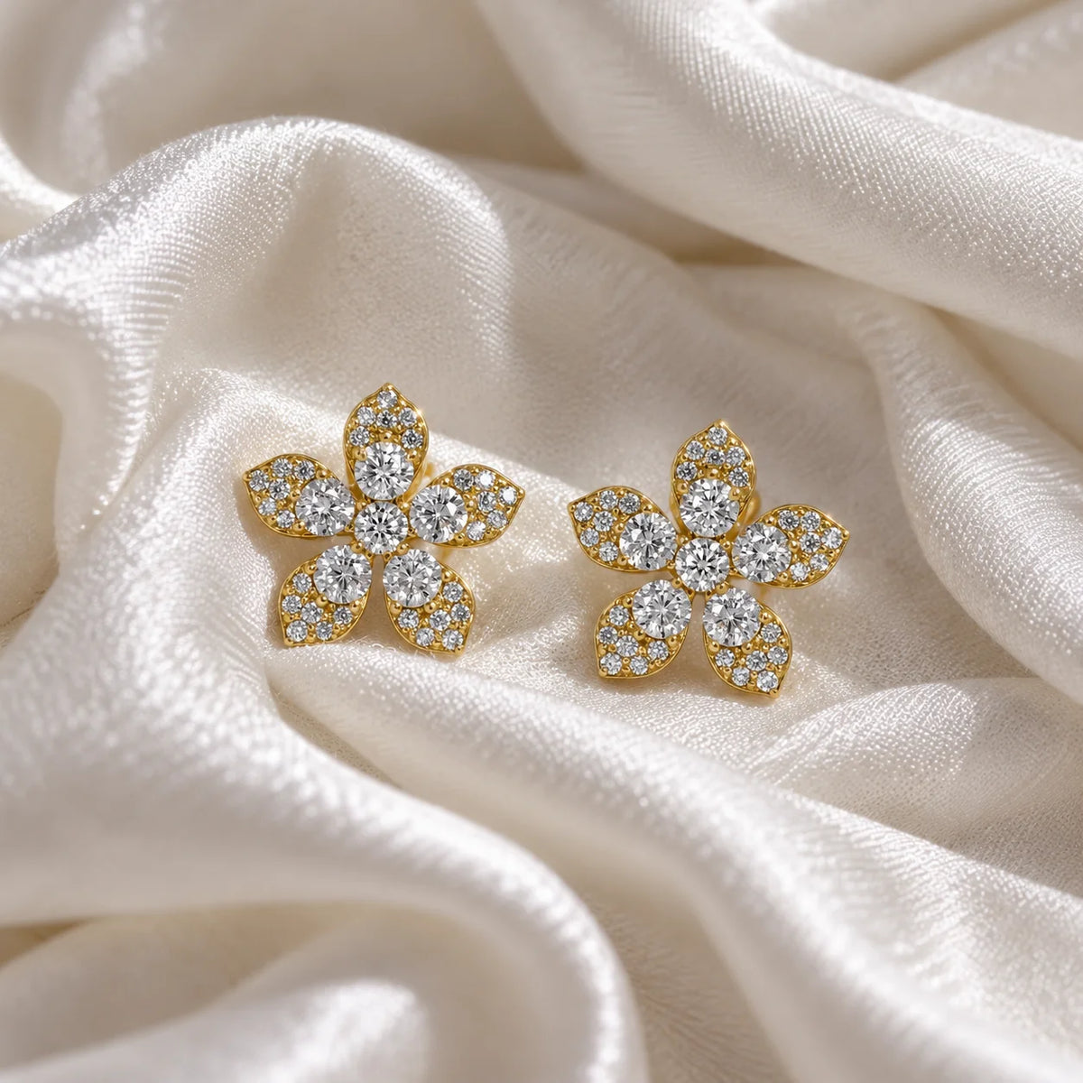 Flower_earrings_in_gold_plated_silver_with_lab_grown_diamonds_at_front_angle_view_on_soft_fabric_background