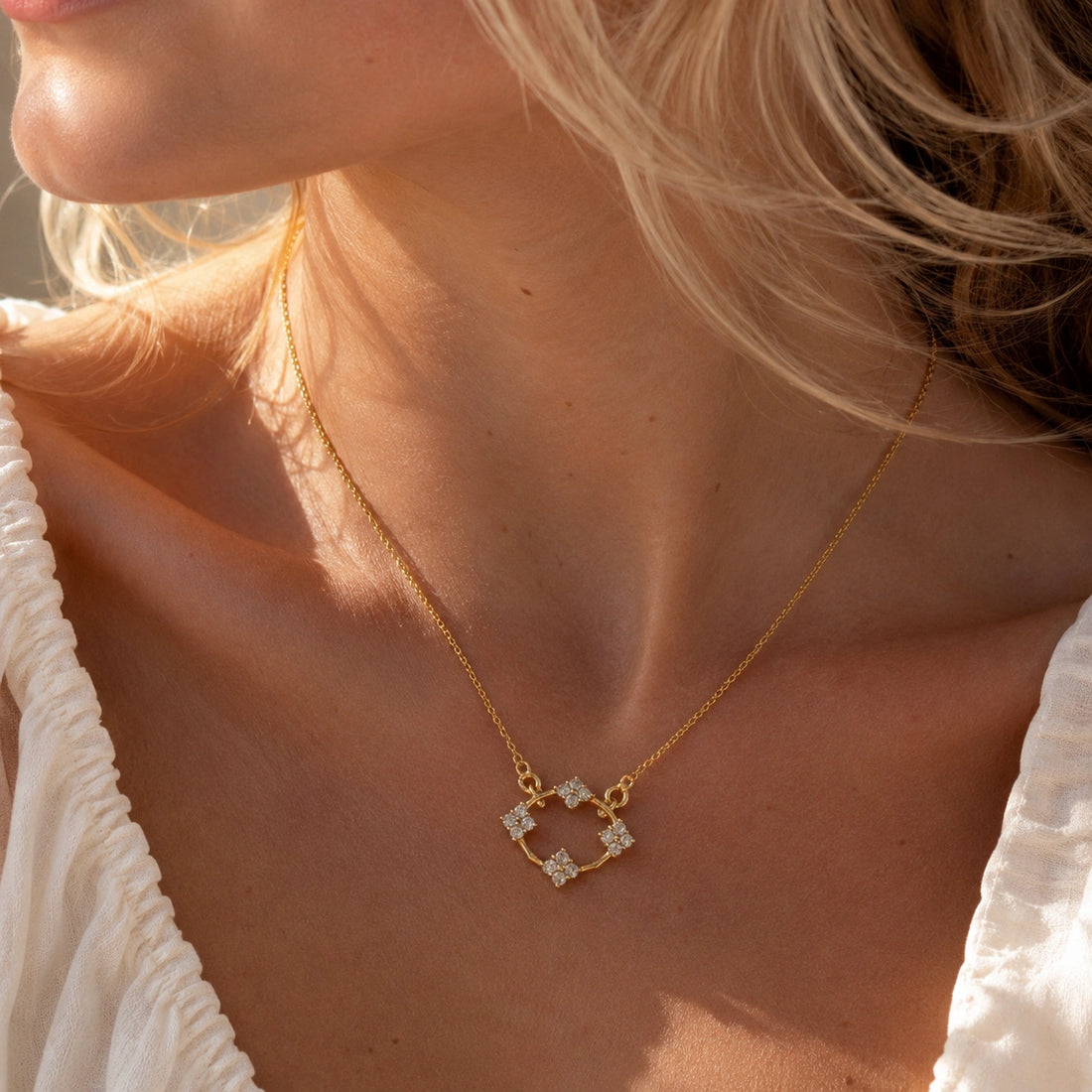 Flower_necklace_with_gold_plated_silver_chain_and_labradorite_stones_at_slight_angled_view_on_soft_fabric_background