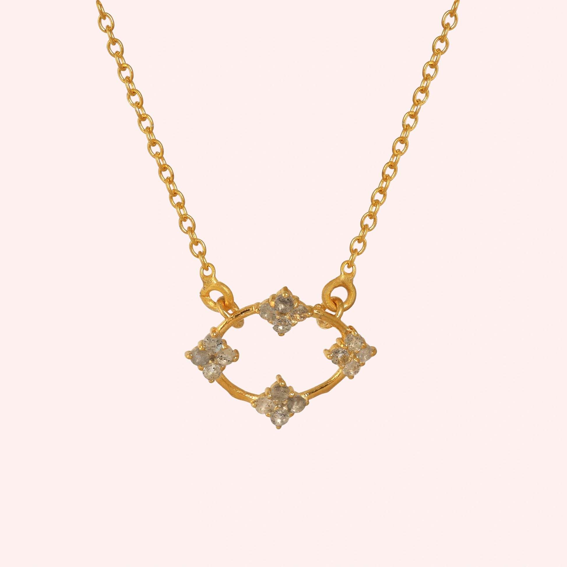 Flower_necklace_with_gold_plated_silver_chain_and_labradorite_stones_at_front_angle_view_on_solid_pink_background
