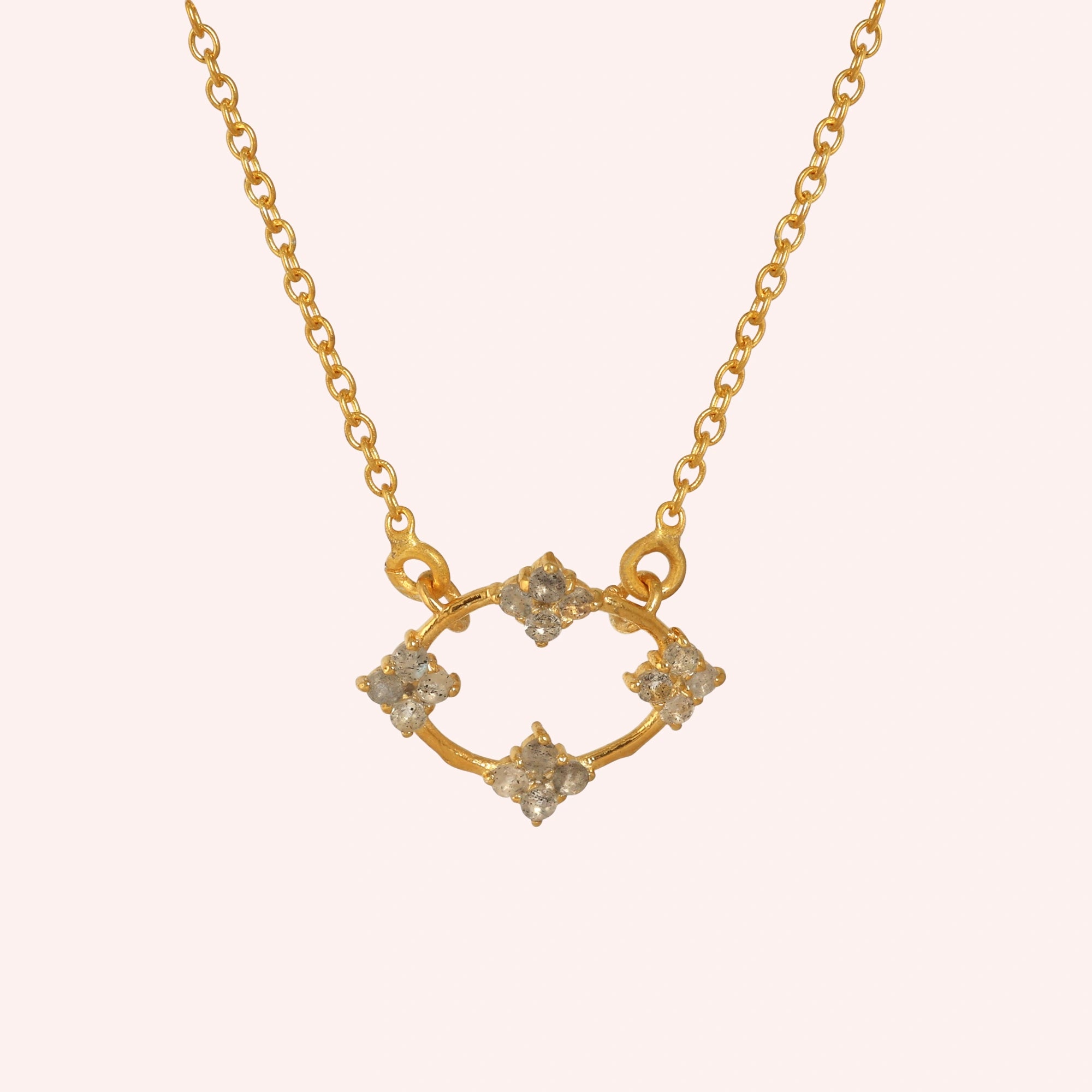 Flower_necklace_with_gold_plated_silver_chain_and_labradorite_stones_at_front_angle_view_on_solid_pink_background