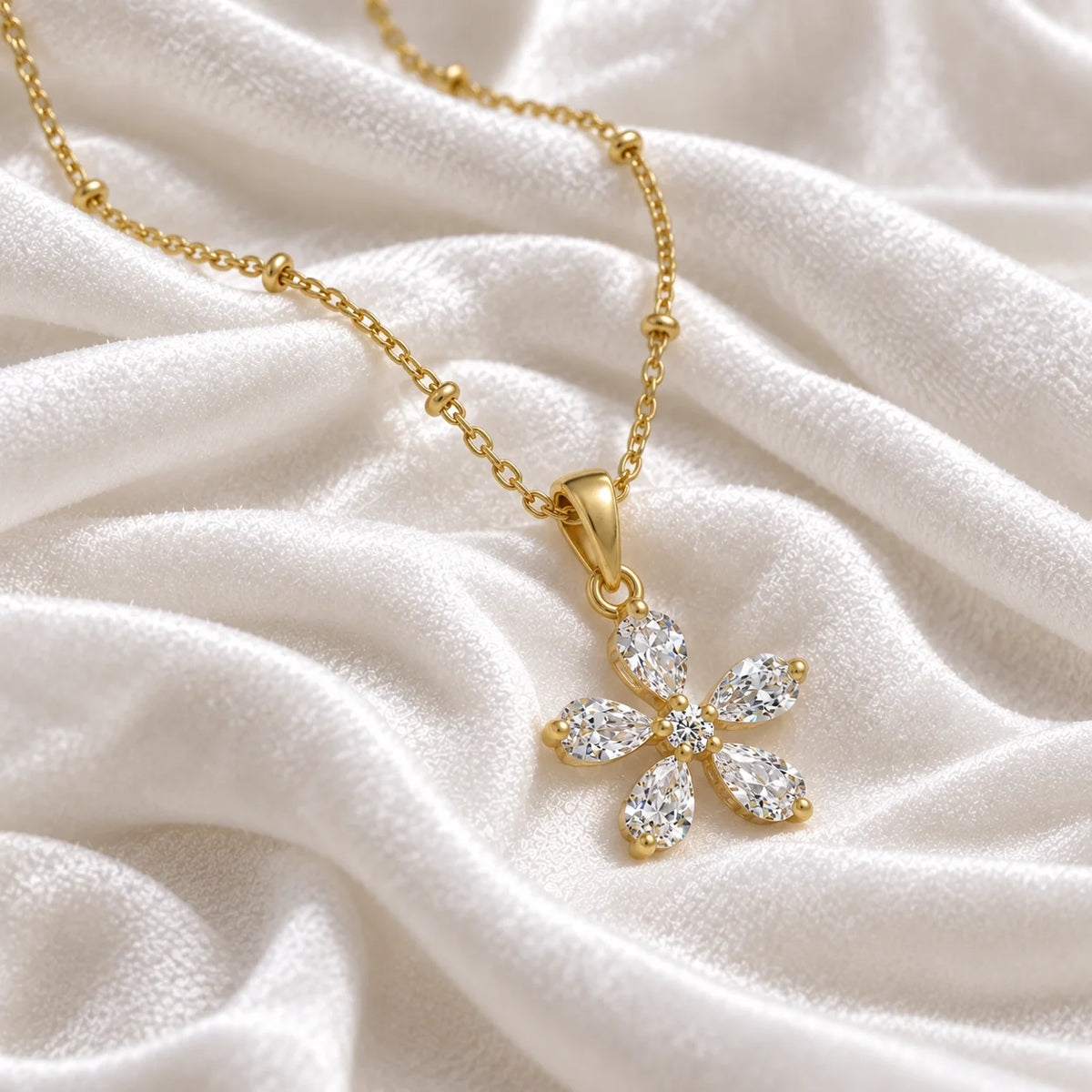 Flower_necklace_in_gold_plated_silver_with_lab_grown_diamonds_at_side_angle_view_on_soft_fabric_background