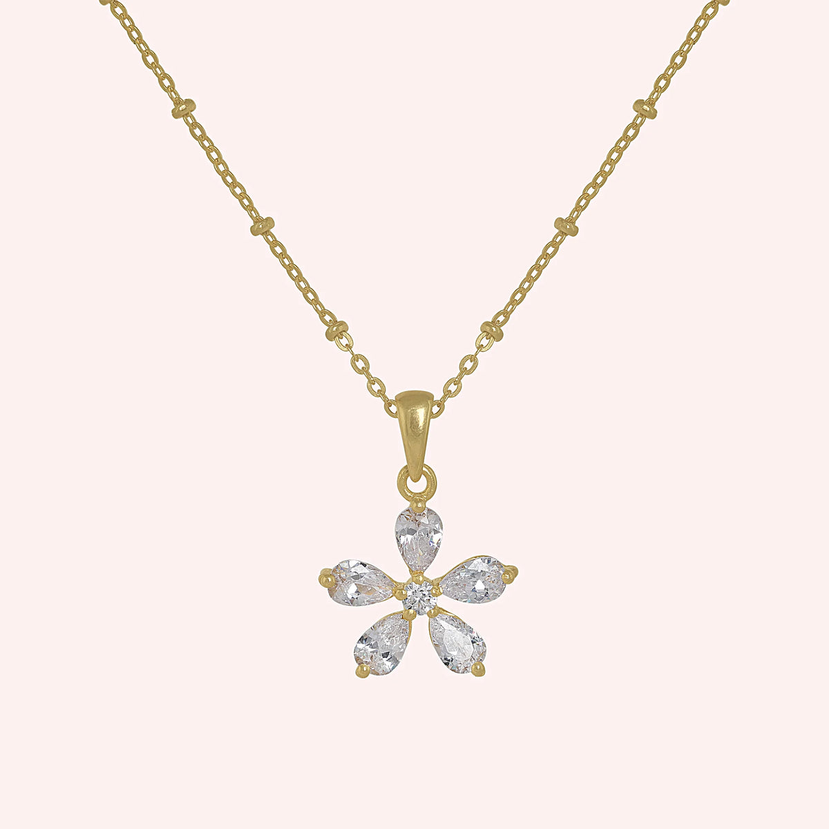 Flower_necklace_in_gold_plated_silver_with_lab_grown_diamonds_at_front_angle_view_on_solid_pink_background