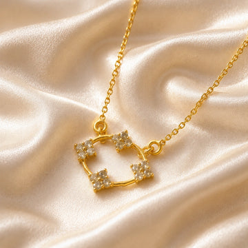 Flower_necklace_with_gold_plated_silver_chain_and_labradorite_stones_at_slight_angled_view_on_soft_fabric_background