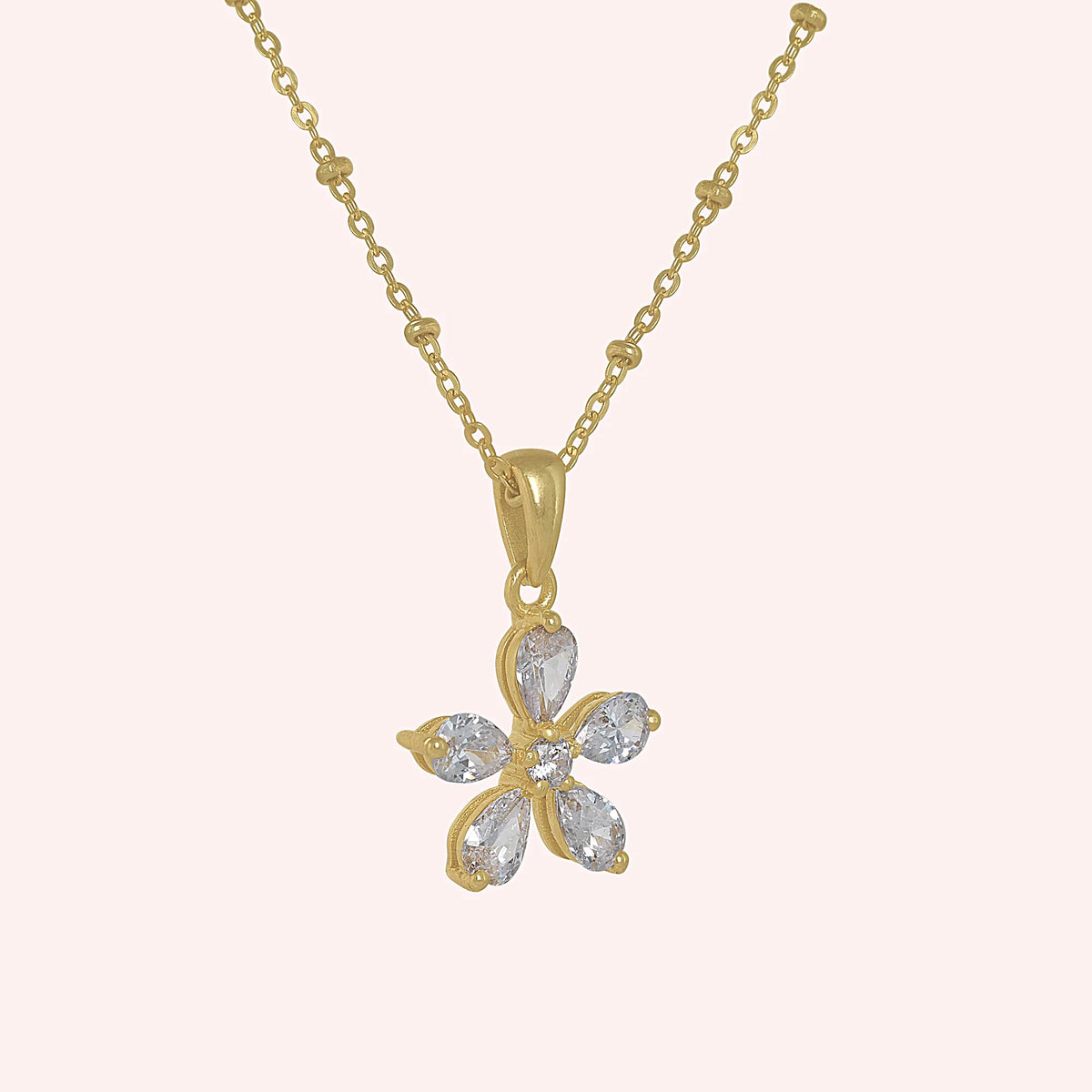 Flower_necklace_in_gold_plated_silver_with_lab_grown_diamonds_at_side_angle_view_on_solid_pink_background
