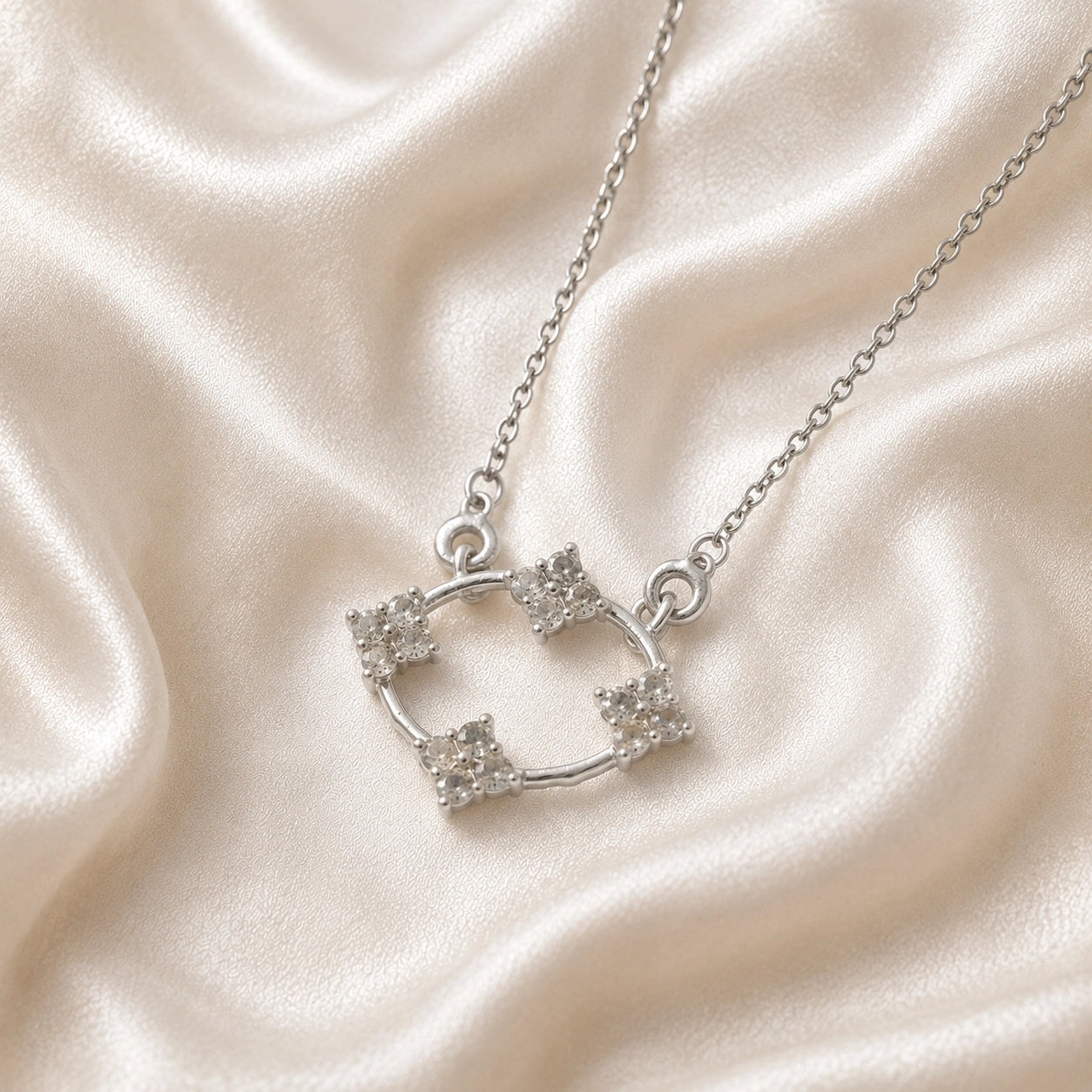Flower_necklace_with_sterling_silver_chain_and_labradorite_stones_at_slight_angled_view_on_soft_fabric_background