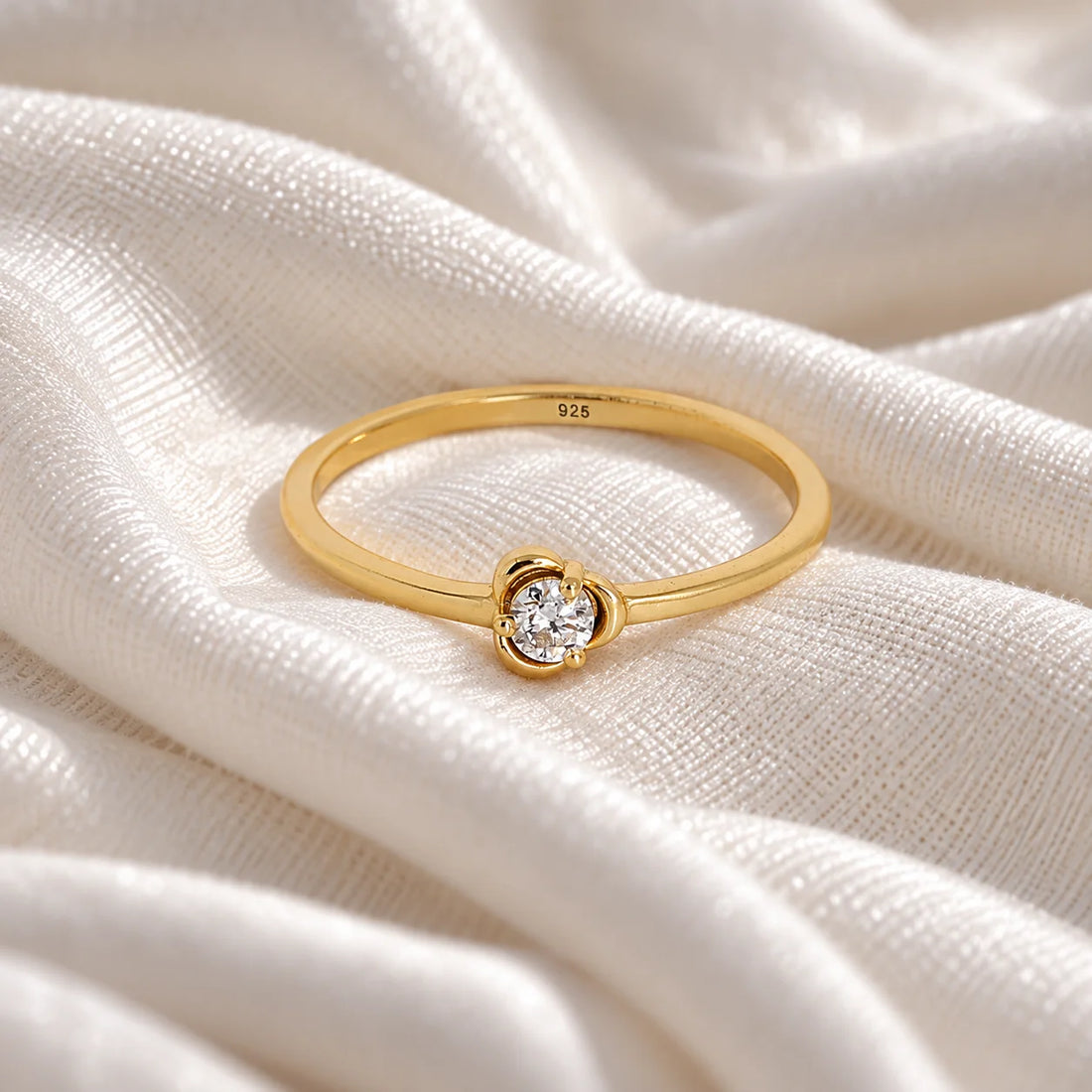 Flower_ring_in_gold_plated_silver_with_a_round_lab_grown_diamond_at_front_angle_view_on_soft_fabric_background