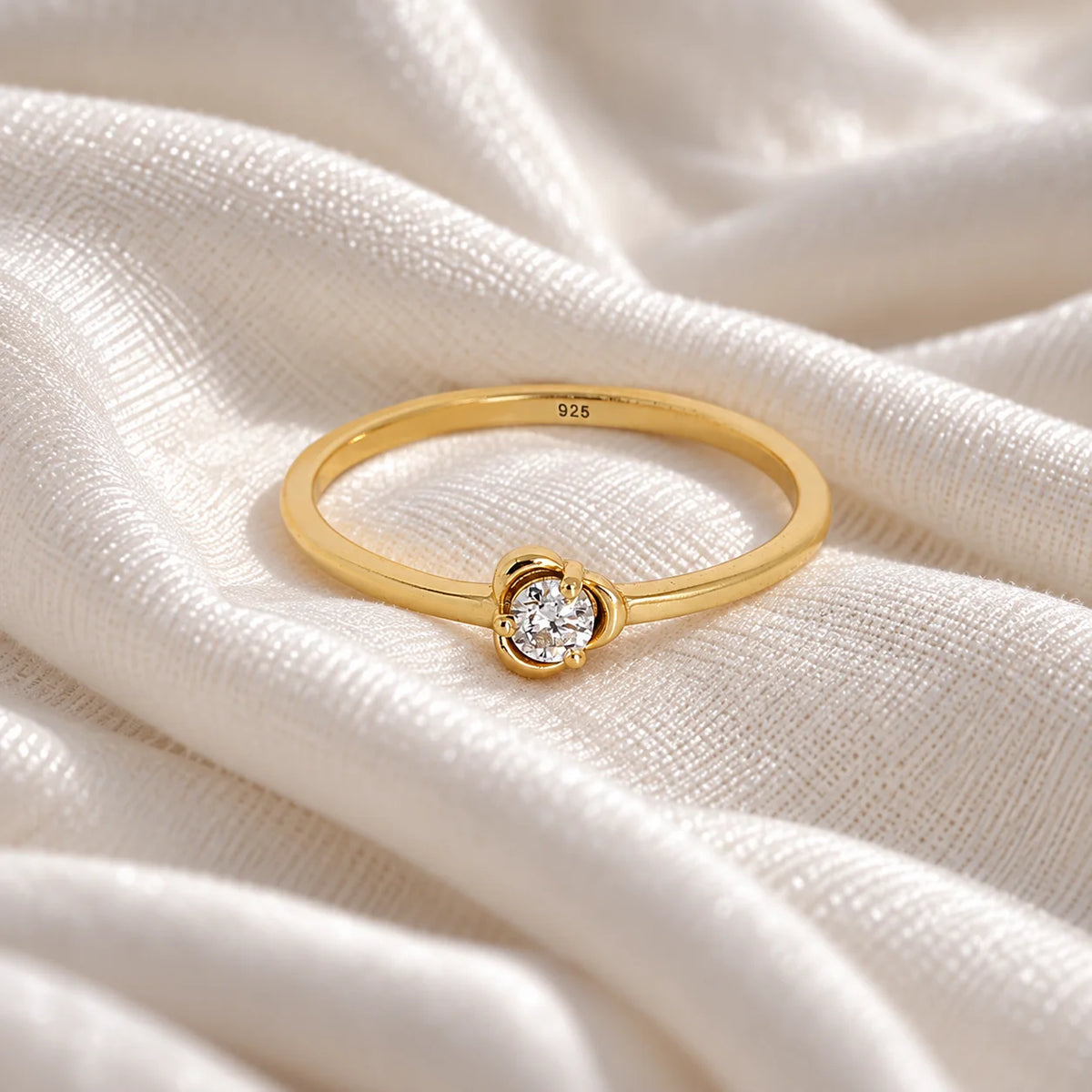 Flower_ring_in_gold_plated_silver_with_a_round_lab_grown_diamond_at_front_angle_view_on_soft_fabric_background