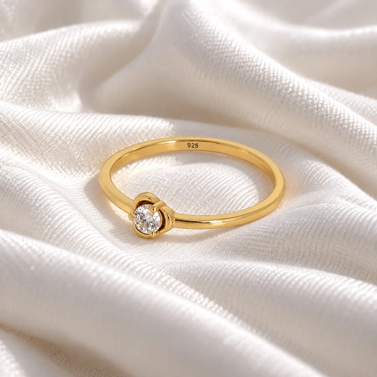 Flower_ring_in_gold_plated_silver_with_a_round_lab_grown_diamond_at_slight_angle_view_on_soft_fabric_background