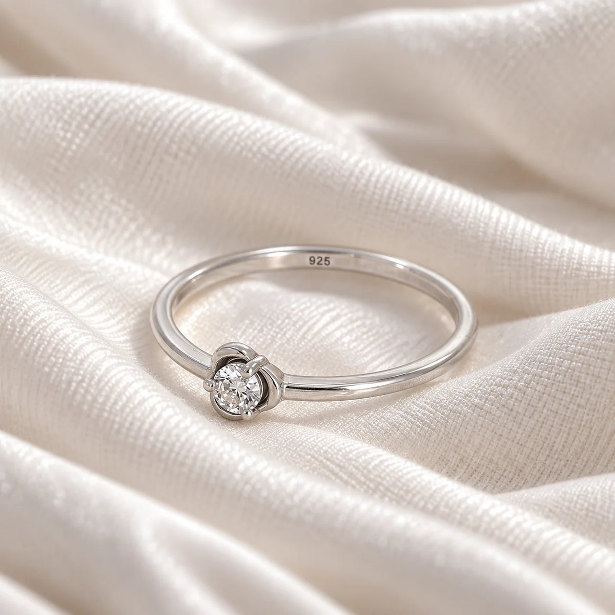 Flower_ring_in_sterling_silver_with_a_round_lab_grown_diamond_at_slight_angle_view_on_soft_fabric_background