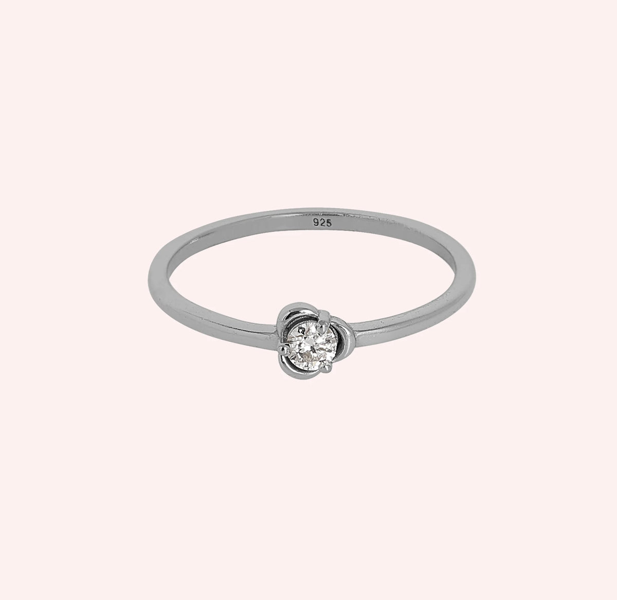 Flower_ring_in_sterling_silver_with_a_round_lab_grown_diamond_at_front_angle_view_on_solid_pink_background