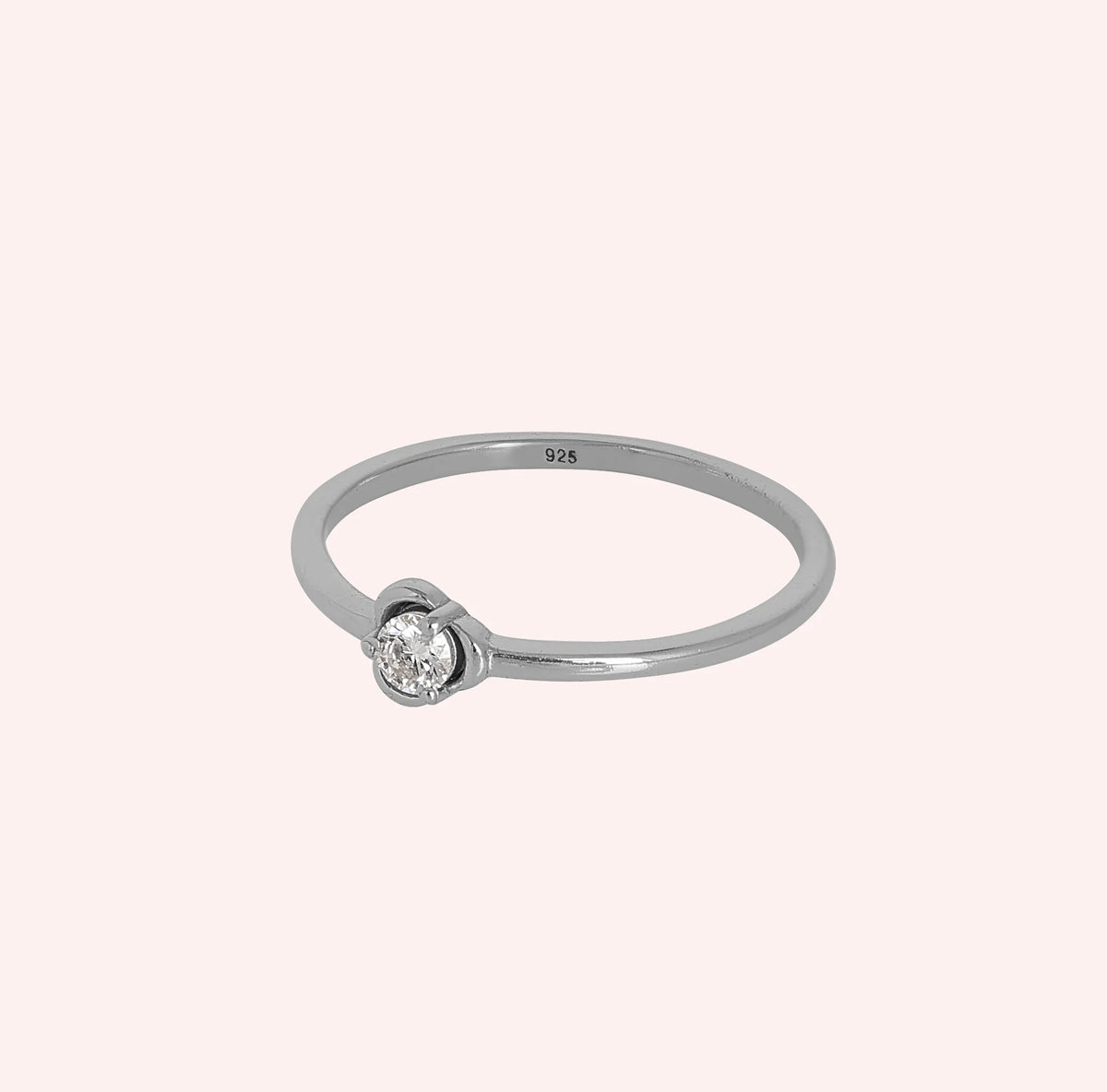 Flower_ring_in_sterling_silver_with_a_round_lab_grown_diamond_at_slight_angle_view_on_solid_pink_background