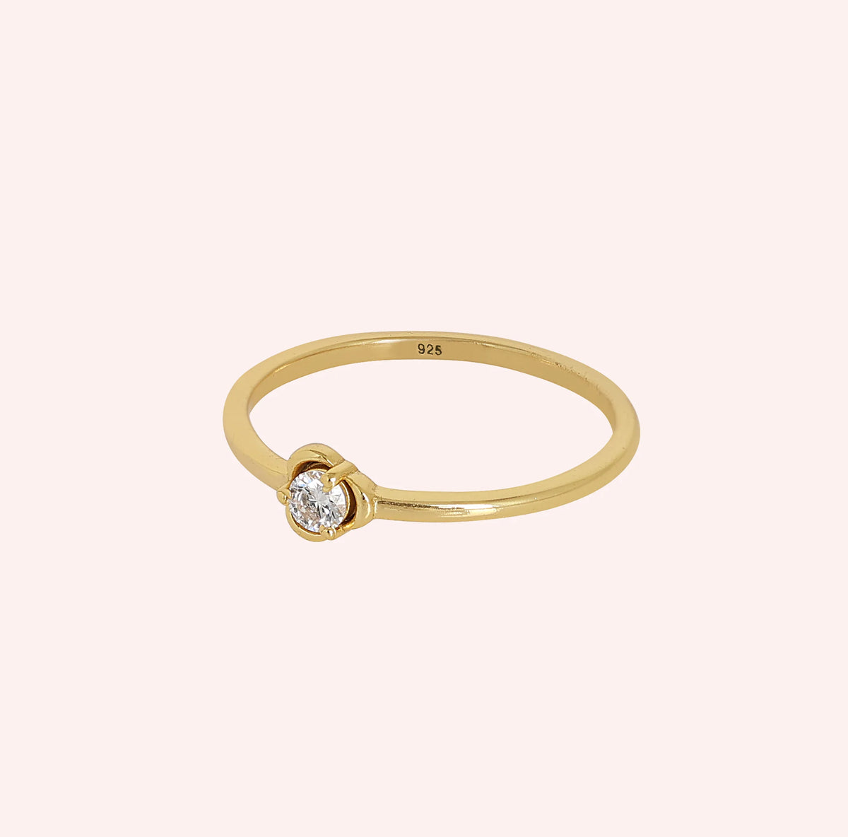 Flower_ring_in_gold_plated_silver_with_a_round_lab_grown_diamond_at_slight_angle_view_on_solid_pink_background