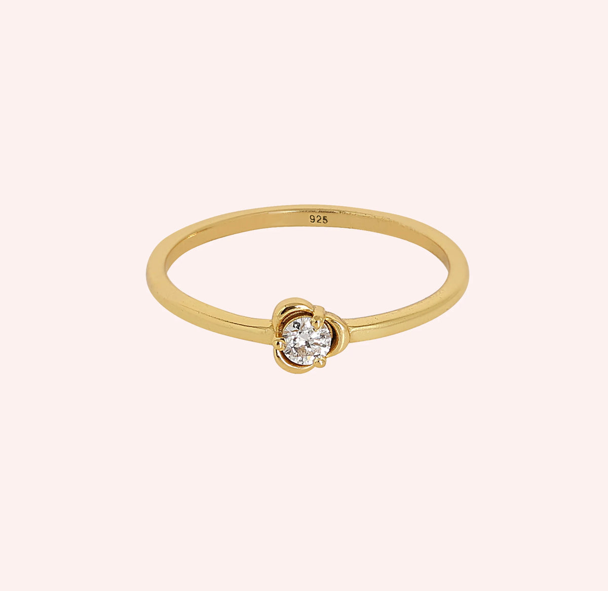 Flower_ring_in_gold_plated_silver_with_a_round_lab_grown_diamond_at_front_angle_view_on_solid_pink_background