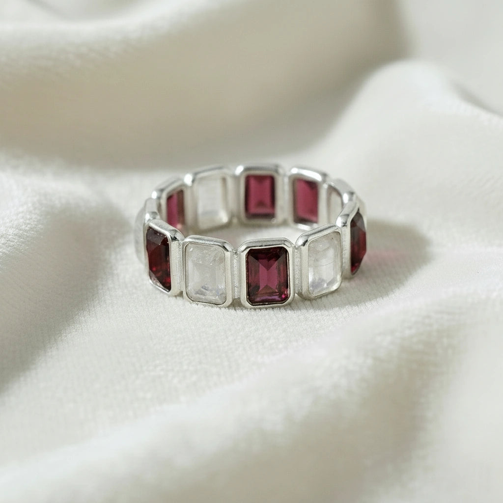 Silver Garnet ring featuring rectangular moonstone and rich Garnet gems on a white velvet fabric background direct front angle.