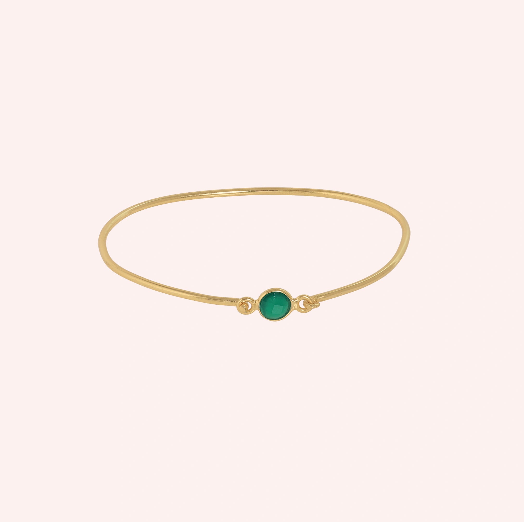 Gemstone_bracelet_in_gold_plated_silver_with_a_round_green_onyx_stone_at_front_angle_view_on_solid_pink_background