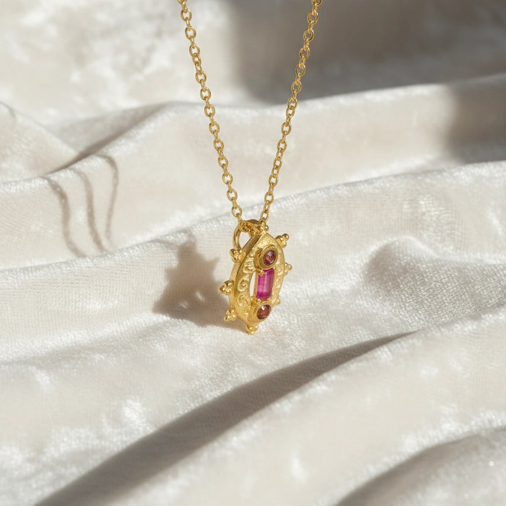 Gemstone-necklace-in-gold-plated-silver-with-pink-and-red-stones-in-side-angled-on-soft-silk-background
