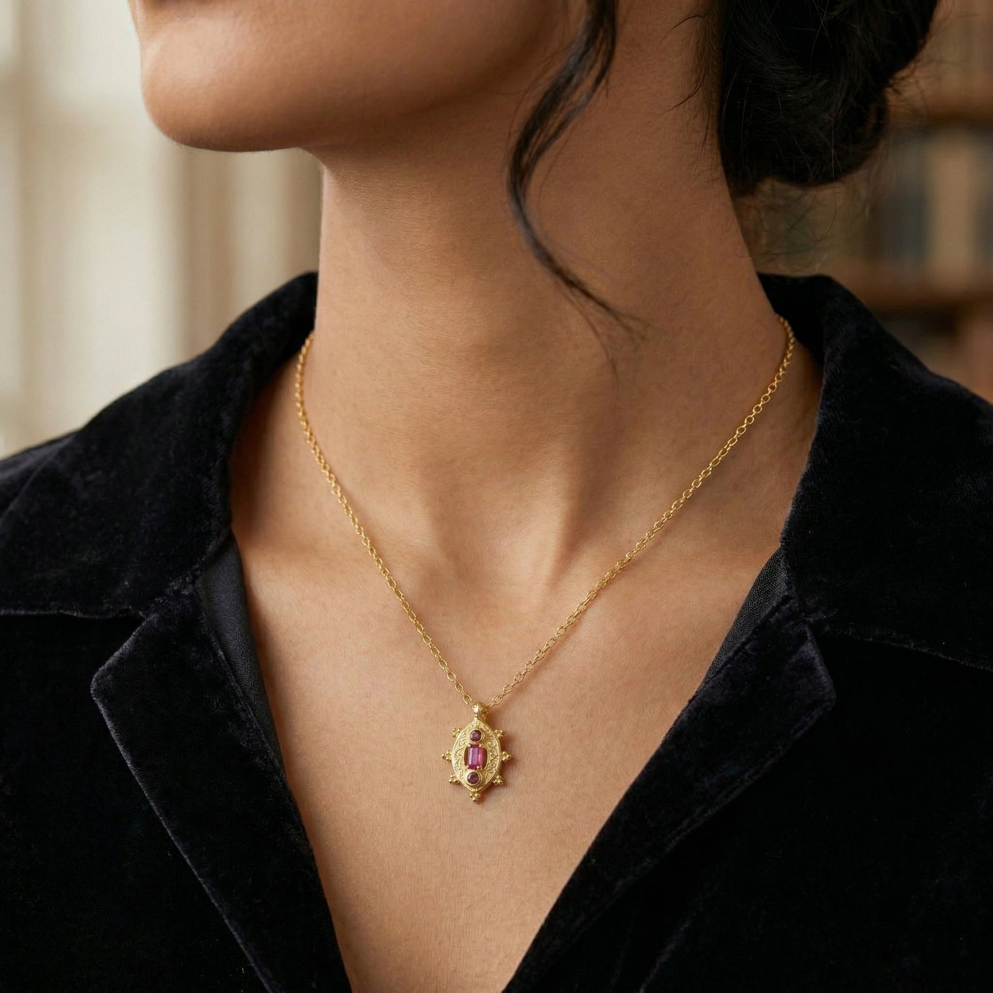 Gemstone-necklace-in-gold-plated-silver-with-pink-and-red-stones-worn-by-a-model-in-natural-light