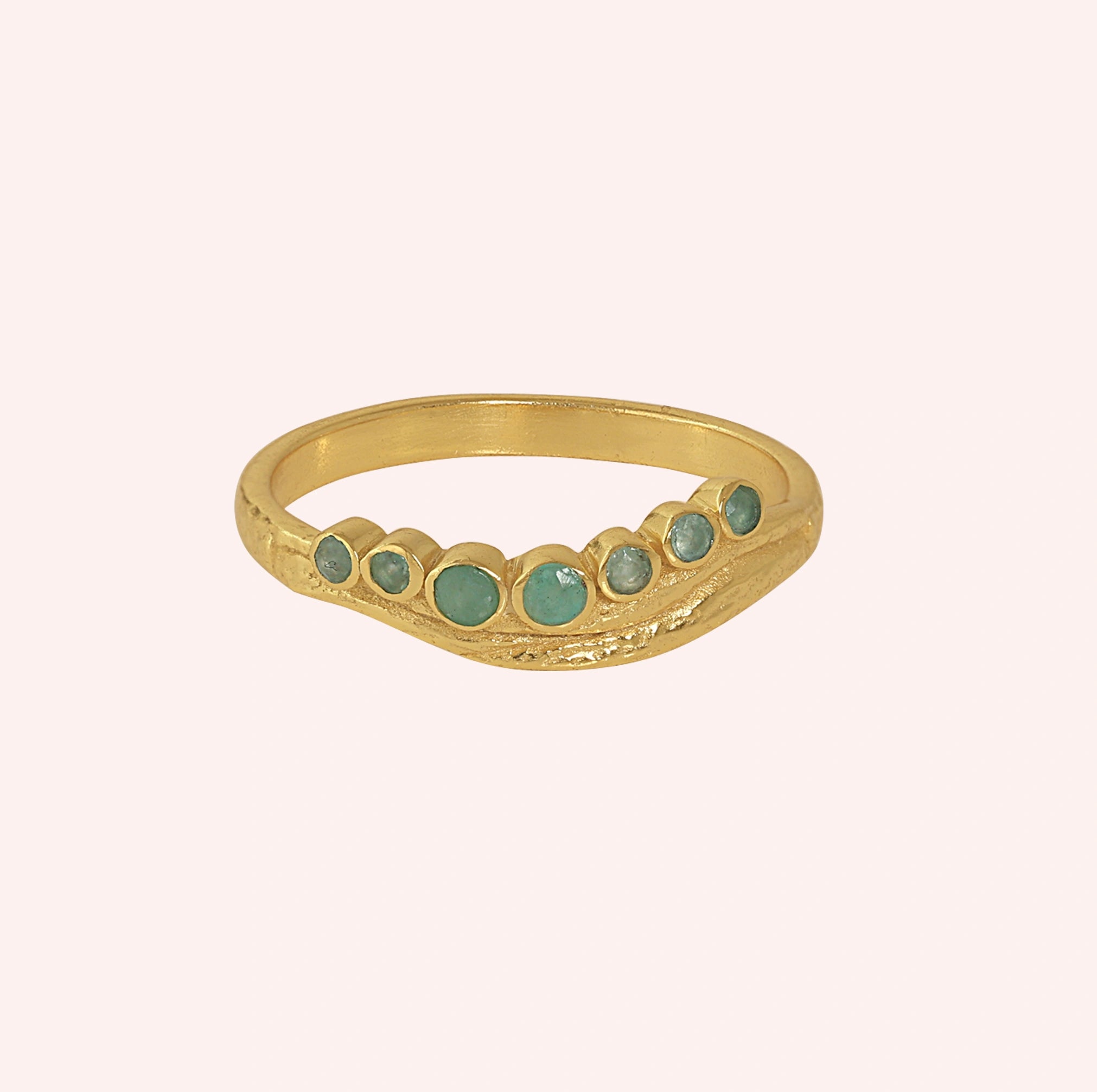 Gemstone_ring_in_gold_plated_silver_at_front_angle_featuring_amazonite_stones_in_a_curve_design_on_solid_pink_background
