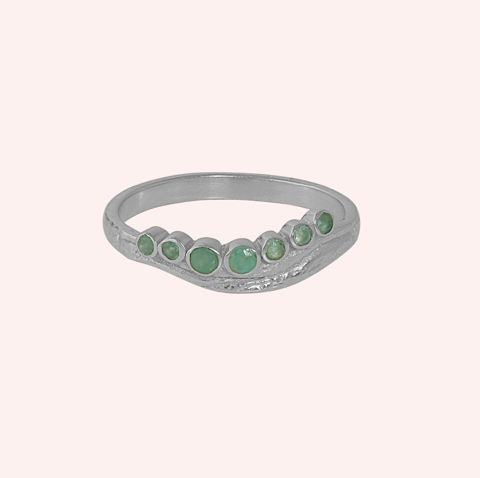 Gemstone_ring_in_sterling_silver_at_front_angle_featuring_amazonite_stones_in_a_curve_design_on_solid_pink_background