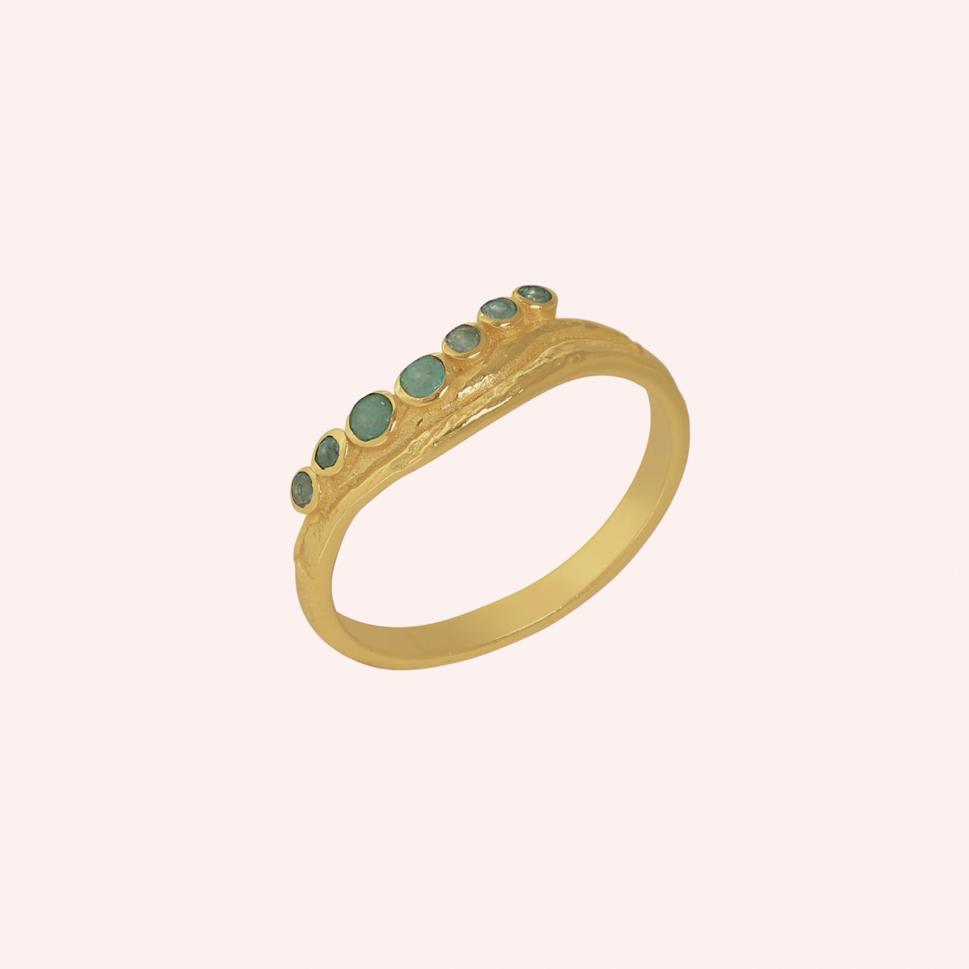 Gemstone_ring_in_gold_plated_silver_at_slightly_angled_featuring_amazonite_stones_in_a_curve_design_on_solid_pink_background
