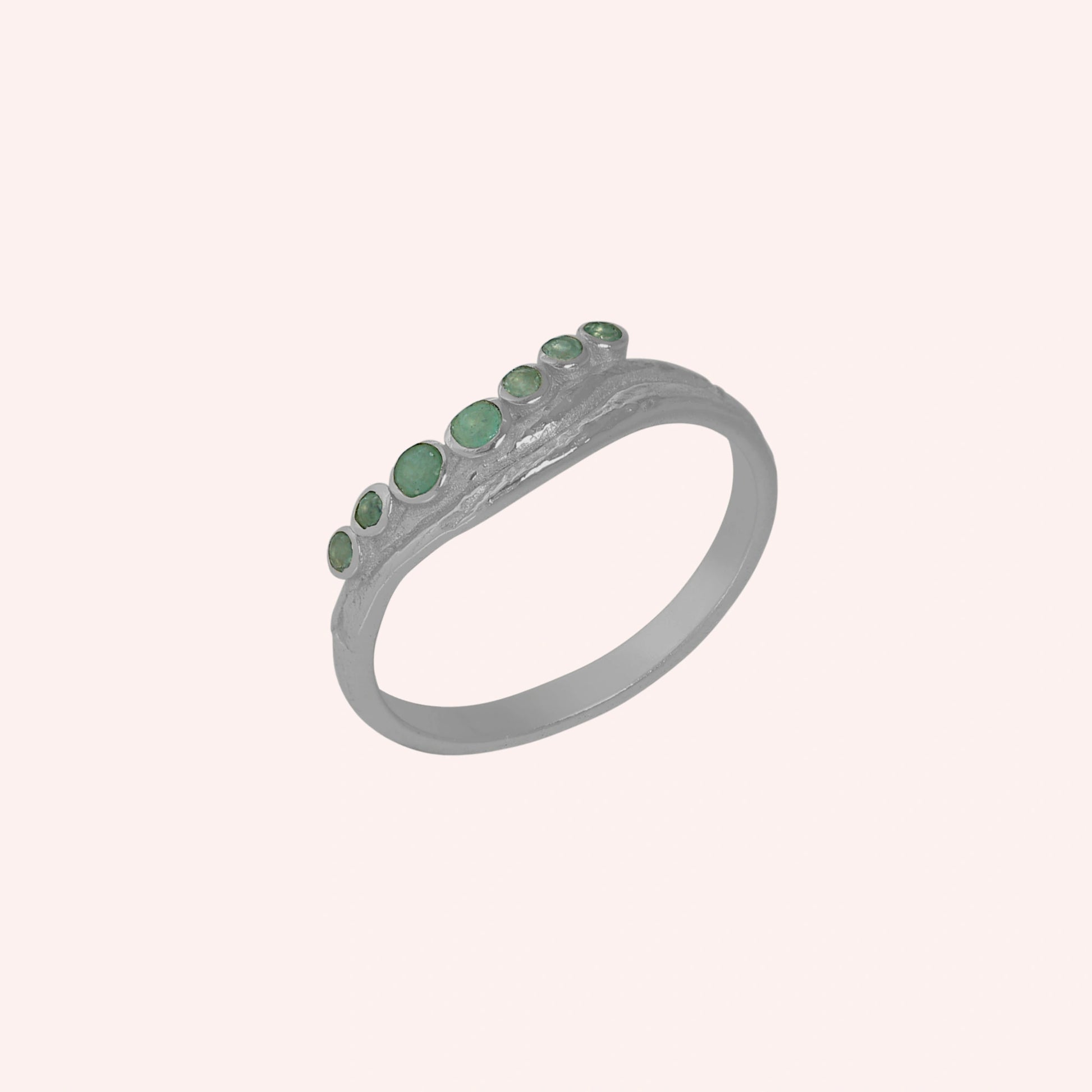 Gemstone_ring_in_sterling_silver_at_slightly_angled_featuring_amazonite_stones_in_a_curve_design_on_solid_pink_background