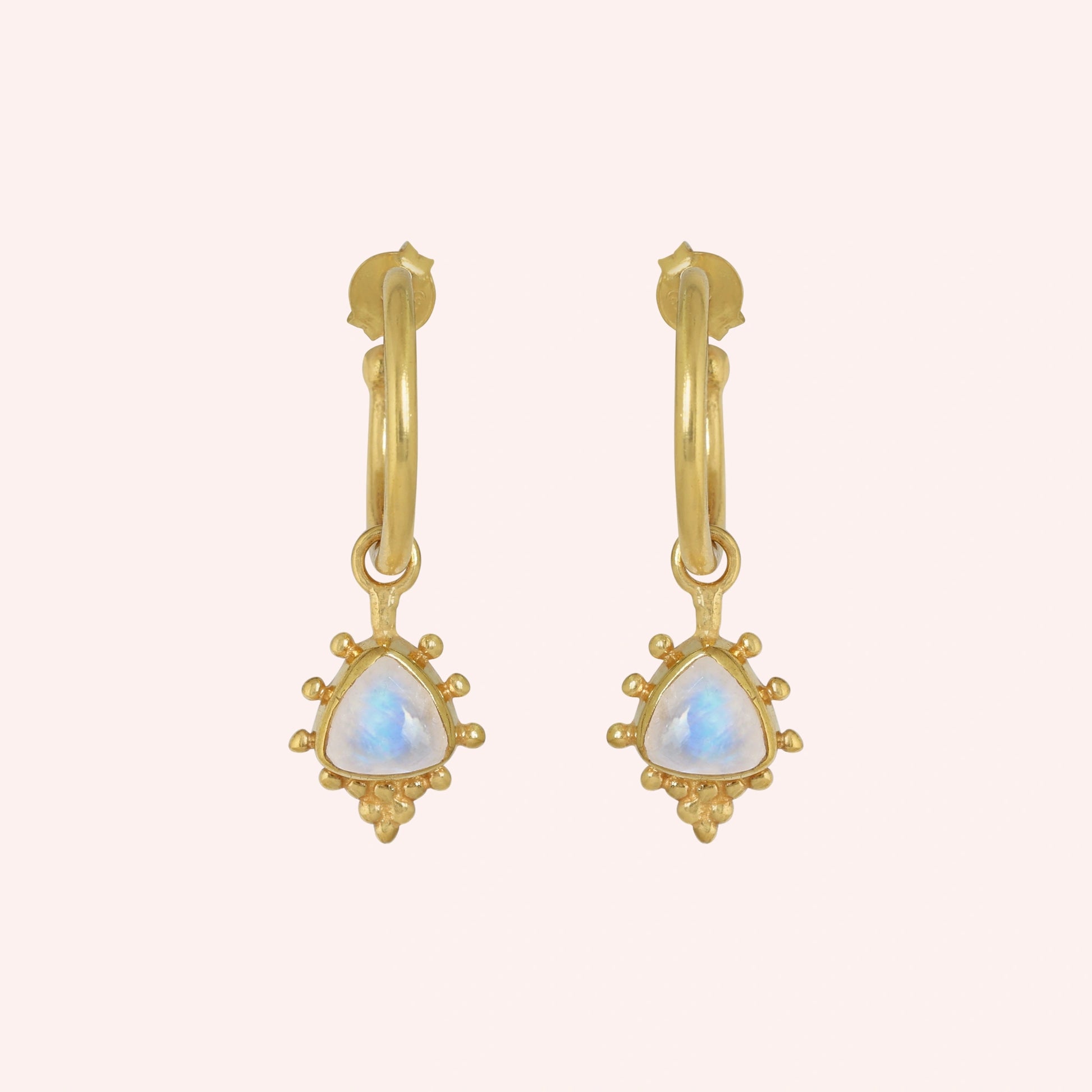 Gold_drop_earrings_in_gold_plated_silver_at_front_angled_with_triangle_moonstone_charms_on_solid_pink_background