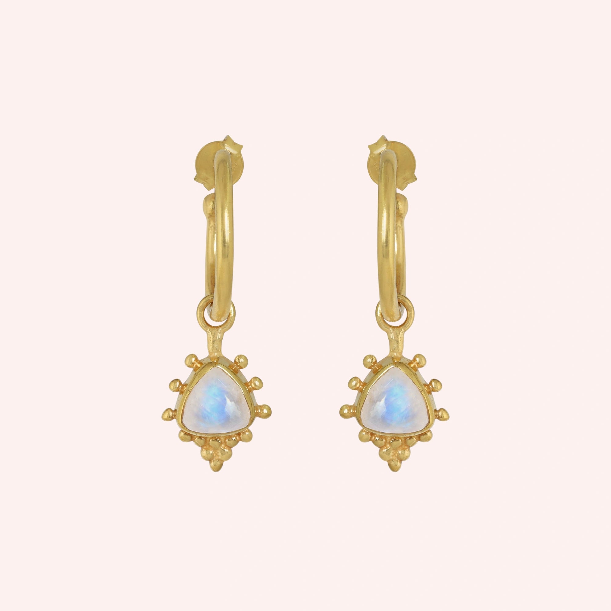 Gold_drop_earrings_in_gold_plated_silver_at_front_angled_with_triangle_moonstone_charms_on_solid_pink_background