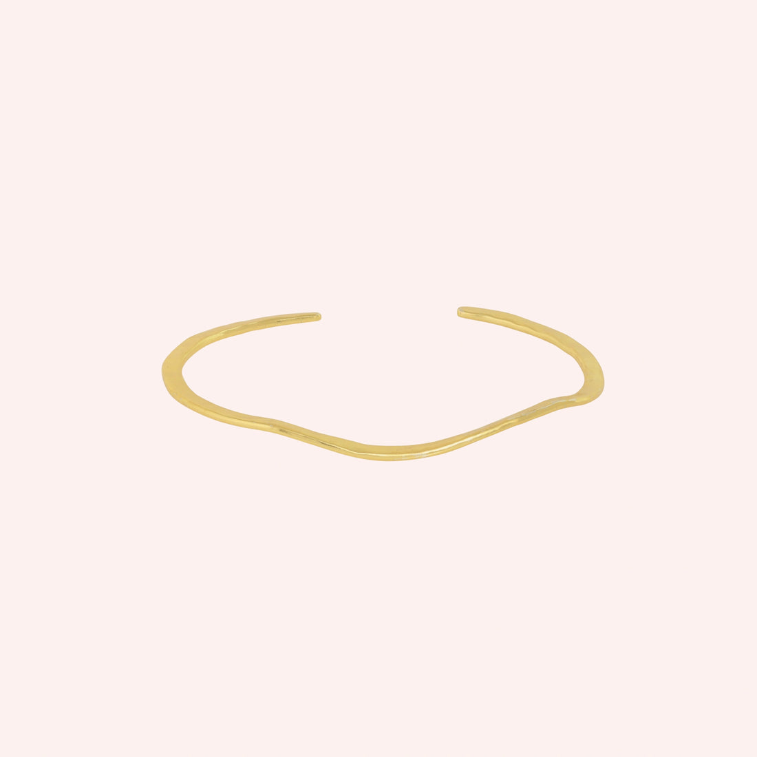 Gold_plated_bracelet_in_gold_plated_silver_with_textured_wavy_band_at_front_angle_view_on_solid_pink_background