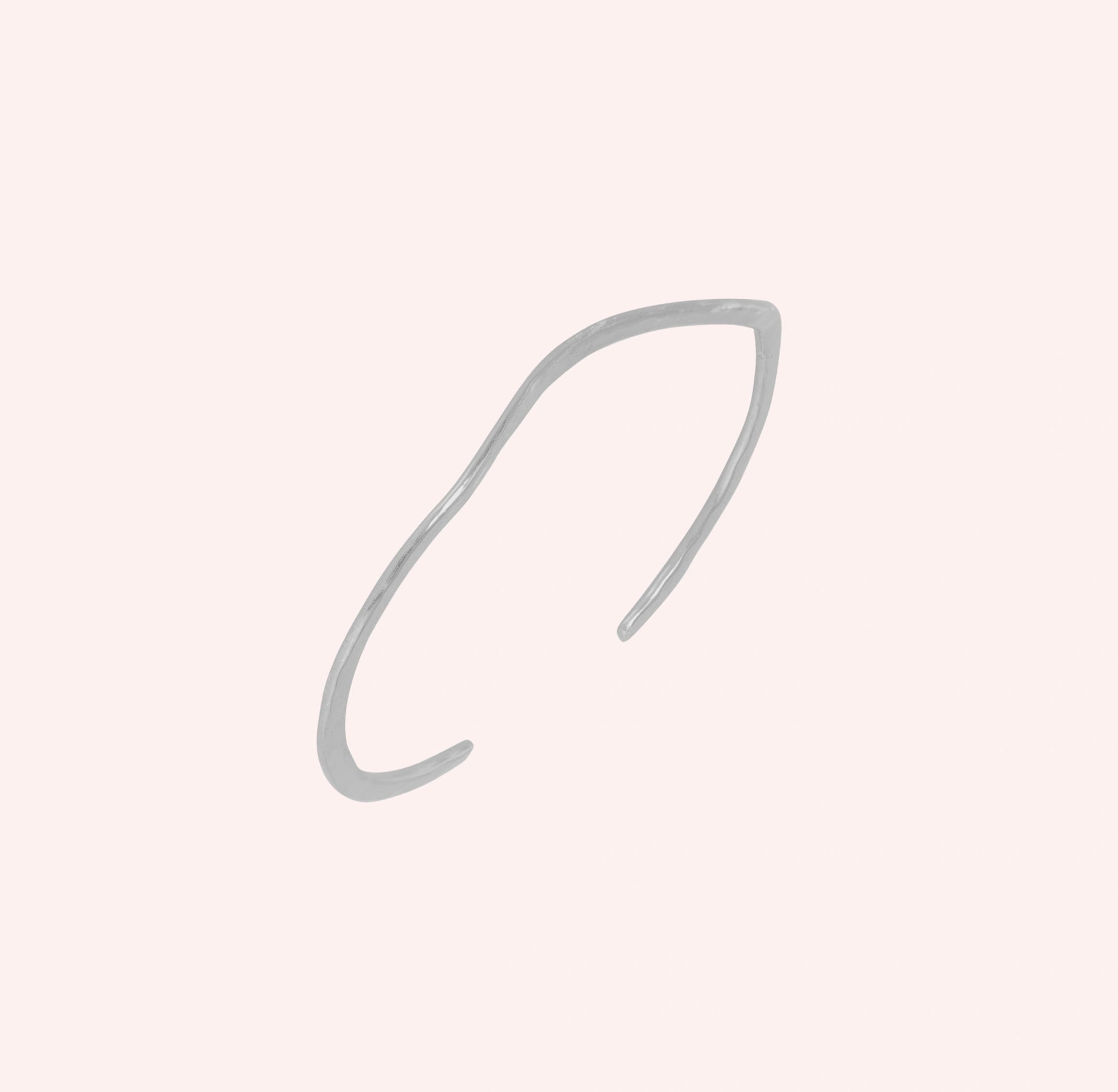 Gold_plated_bracelet_in_sterling_silver_with_textured_wavy_band_at_slight_angle_view_on_solid_pink_background