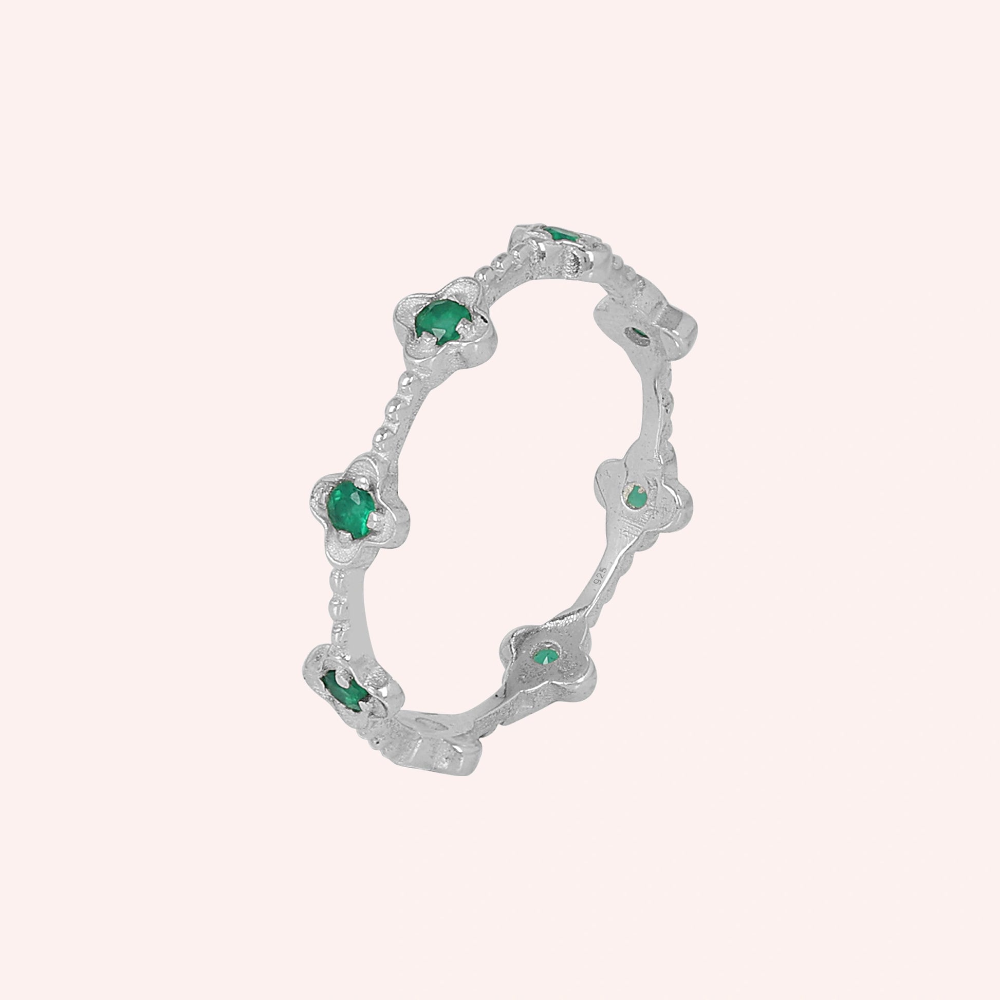 Sterling silver floral green onyx eternity band ring angled slightly left on a pink background detailed product jewelry shot