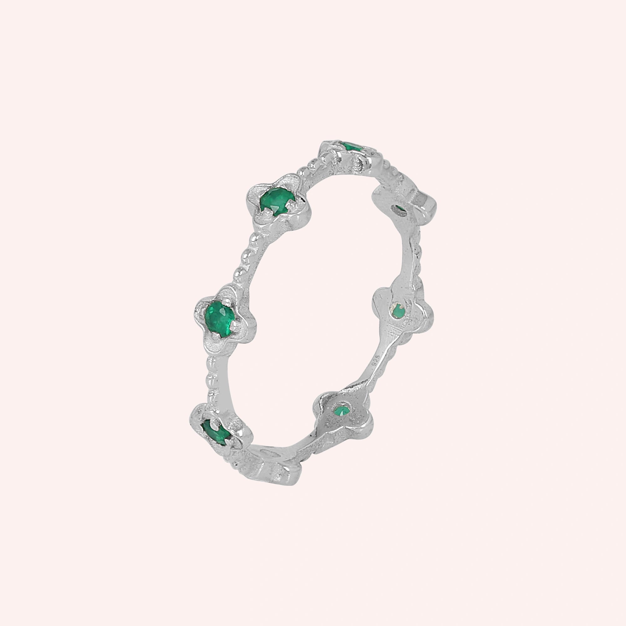 Sterling silver floral green onyx eternity band ring angled slightly left on a pink background detailed product jewelry shot
